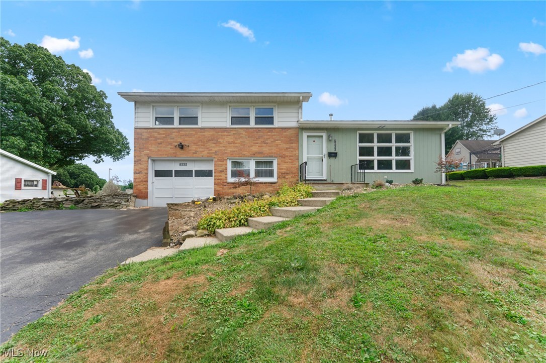 Welcome to this spacious split-level home in the Hubbard School District, offering 3 bedrooms, 2 full bathrooms, and over a half-acre of property. The exterior features vinyl siding with a brick face, a composite front porch deck, three-tab shingle roof, and a one-car attached garage. Inside, the main level opens to a bright living room with vinyl plank flooring that flows into the dining area and has access to the back patio. The kitchen offers wood cabinetry, red laminate countertops, a tile backsplash, wall oven, refrigerator, and electric cooktop. Upstairs, you’ll find three bedrooms, each with solid hardwood flooring and double closets, including one with a cedar closet. The full bath on this level has been extended and updated with a walk-in shower, tile details, and the added convenience of a second-floor laundry area. The lower level provides a comfortable family room and a second full bath with walk-in shower, tile walls, tile flooring, and a modern vanity. The basement includes a high-efficiency furnace and central air (2024), hot water tank, 100-amp panel, tons of storage, and space for a home gym or hobby area. Out back, enjoy a spacious patio perfect for entertaining, plus a shed for storage. With public water, public sewer, and plenty of updates, this home combines comfort and functionality in a great location. Don't miss out!!