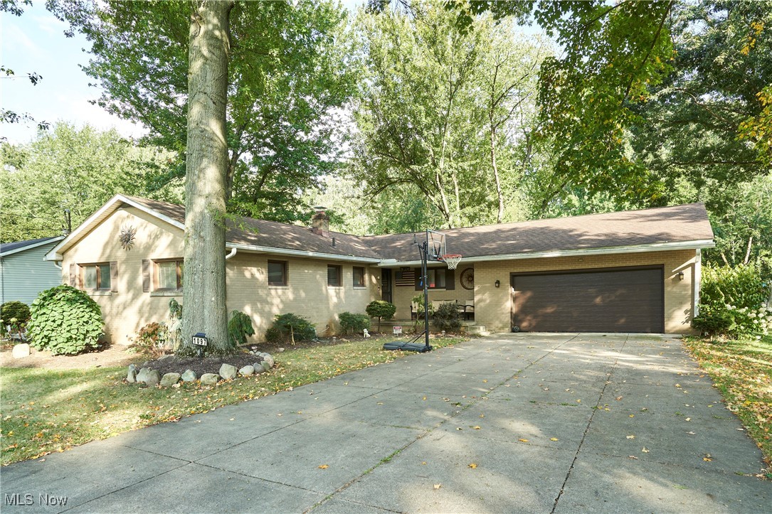 Welcome to this beautifully maintained all-brick ranch offering 1,672 sq. ft. of above-grade living space, plus an additional 1,522 sq. ft. in the walk-out lower level. Situated on a 1.09-acre lot in Copley Twp, mature shade trees surround this home and back up to several acres of serene woods. Upon entering the home, you’re welcomed by an oversized kitchen with large windows overlooking the deep backyard. Just off the kitchen, you’ll find a convenient first-floor laundry/pantry area and access to the garage. The spacious living room features a wall of windows and a door that leads to an expansive screened-in porch—ideal for relaxing or entertaining. Hardwood floors lie beneath the carpet in all bedrooms and the hallways. The master bedroom offers an updated ensuite complete with a walk-in shower, vanity, and toilet. Two additional bedrooms and a large hallway bath complete the main level. Downstairs, the fully finished walk-out lower level includes a spacious rec room anchored by a stunning full-wall limestone fireplace. This level also offers a fourth bedroom and half bath, providing excellent flexibility for family, guests, or a home office. Large above-grade windows fill the space with natural light, and a walk-out door leads to a stone patio. Just beyond, a tiered retaining wall creates an ideal setting for raised garden beds. The LL also offers a large storage room and the well/pump room. Additional highlights include an attached 2-car garage equipped with a 220 line, a walkable attic that provides excellent storage, an extra-wide concrete driveway, glass block windows, and a welcoming covered front porch. Updates include: hot water tank and A/C (5 years old), new well pump, updated 200-amp electrical panel, boiler (replaced 9 years ago), and newer stainless steel appliances, including washer and dryer. Within the last 5–6 years, the current owner also finished the lower-level bedroom and half bath.