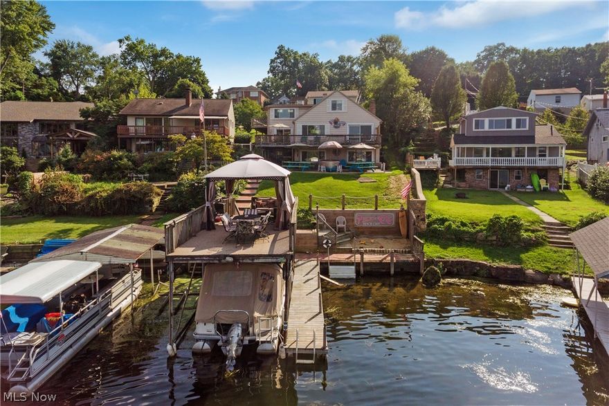 Want a lake house just in time for summer? What a view!! This one-of-a-kind, pristine, & meticulously maintained lakefront is truly a *must-see* ~ loaded w/ character and features on the main chain of beautiful Portage Lakes..gorgeous million dollar views of East Reservoir and private cove. So much to offer - PUBLIC sewer, 2990 sq ft, 4-5 bedrooms, 3.5 baths, .40 acre lot, tons of parking & 3 car garage w/ 32 X 26 workshop w/ gas and electric, w/ potential for finishing more living space! Plenty closet space & storage & amazing entertaining space. Bridge leads to mother-in-law or guest suite w/ 2 beds, full bath, kitchen, dining, living room, not requiring stairs. Rare find in PLX - a 3 car garage w/ NEW 100 AMP service and heat, property, MEGA parking space, parking pad, w/ huge driveway for all your guests. Main level features NEW hickory hardwood floors, formal dining room, maple kitchen & floors with NEW appliances & double-oven, full bath, master bedroom overlooking the lake and w