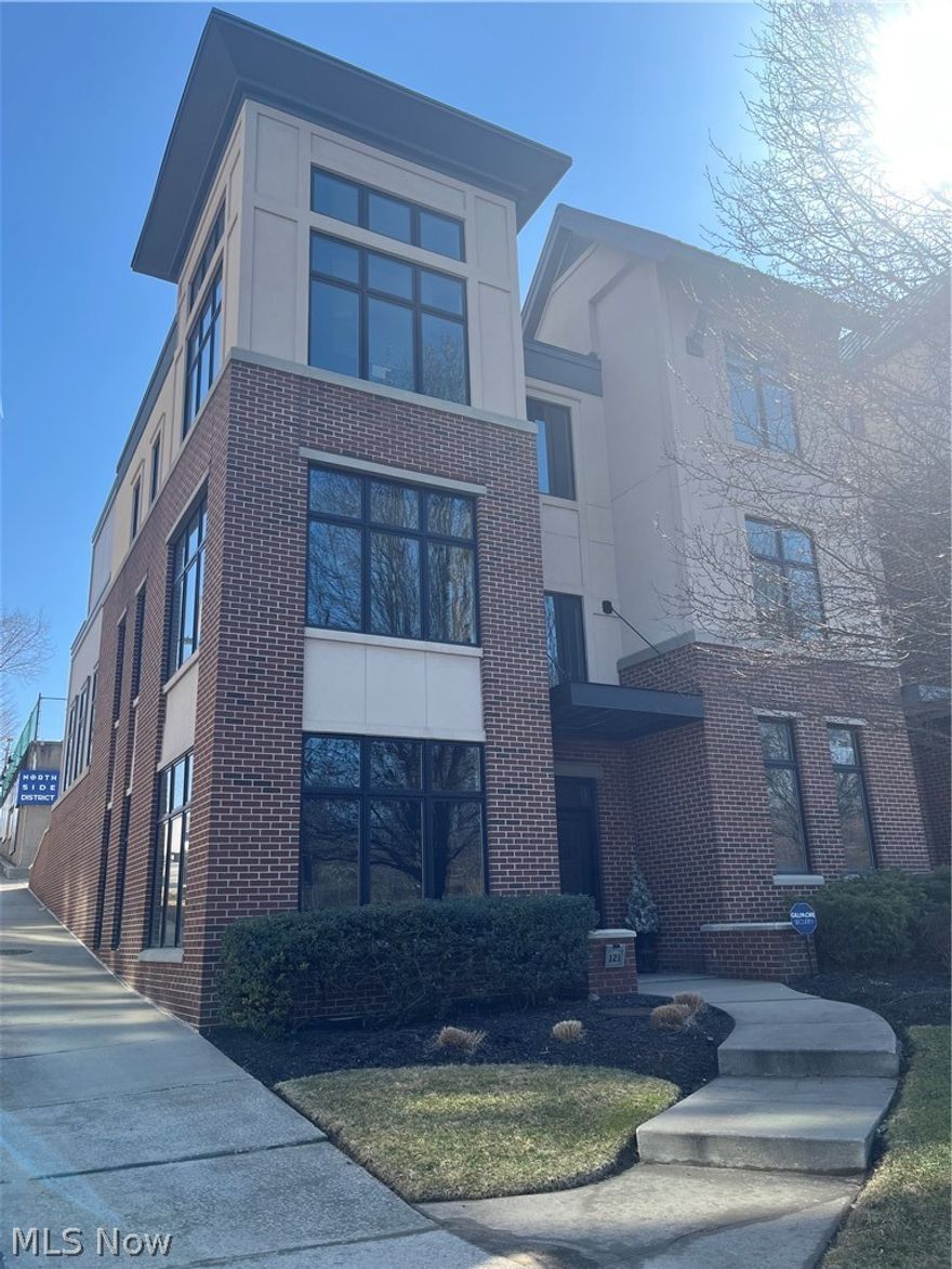 Welcome to Akron's vibrant Northside District, where culture, convenience, and luxury come together.

This stunning corner-unit townhome is just steps from downtown Akron's top restaurants, coffee shops, hospital systems, arts venues, and scenic trails. Recently updated in 2024 and 2025, the home is move-in ready with fresh paint and all-new modern lighting inside and out.

Inside, an expansive open-concept living space is filled with natural light from dramatic floor-to-ceiling windows, offering breathtaking views of the Cuyahoga Valley. The chef's kitchen features a large island, new granite countertops, updated sink and fixtures, and newer appliances, perfect for entertaining. A new modern surround fireplace adds warmth in the winter, while a private deck provides a relaxing outdoor retreat in warmer months. The main level also includes a beautifully updated designer half bath.

Upstairs, the primary suite offers a peaceful retreat with wall-sized windows, a spacious walk-in closet with new systems, and a hotel-inspired en-suite bath featuring an oversized LED mirror, updated fixtures, a new toilet, a soaker tub, and a walk-in shower. The second bedroom is currently a custom closet but can easily be converted to suit your needs, whether as a home gym, nursery, gaming room or guest space. A dedicated home office adds flexibility for remote work.

The finished lower level is ideal for entertaining, complete with a stylish wet bar, wine refrigerator, new granite countertops, new sink, built-in cabinetry, and an additional bathroom.

A two-car attached garage and easy freeway access make daily living effortless. Enjoy weekends exploring nearby trails, entertainment, and dining just outside your door.

This is downtown luxury with nature at your window, schedule your private showing today.