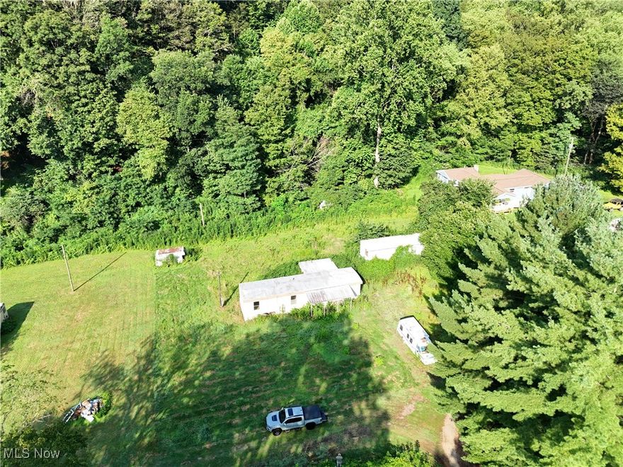 16+ mostly wooded acres with a nice timber growth and a level area with 2 existing as-is mobile homes. Fun little getaway property with enough flat area for a cabin site and 14+ acres of wooded land. Island Creek is meandering through the front of the property and property is access via a shared bridge. Woods water and seclusion, it kind of fits the bill people are looking for in a getaway property.