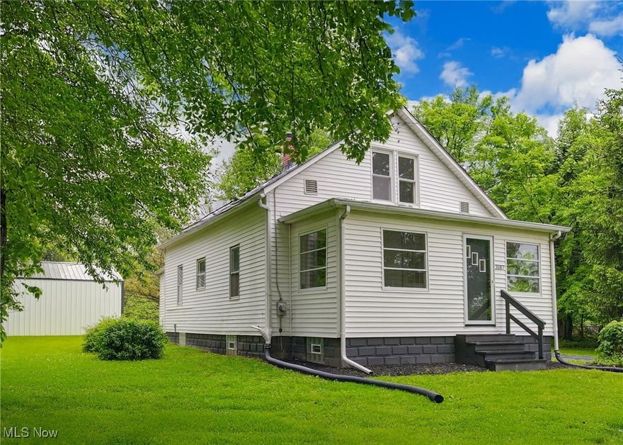 Welcome to 3187 Grenfall Rd. Norton OH 44203. Nestled in a quiet, mature neighborhood on over 2 acres in Norton, sits this beautifully renovated bungalow that seamlessly blends classic charm with modern finishes. The enclosed front porch has been transformed into a bright and airy transitional space that would be the perfect spot to enjoy a morning coffee or greet guests before stepping into the home. Once inside, enjoy a spacious and open but warm and inviting atmosphere throughout the entire main floor. Imagine yourself cooking in the fully updated kitchen as you watch the kids play in the living room or entertaining family and friends with ample amount of seating and space for every loved one. Another wonderful feature of this home is capability of one floor living with a bedroom, updated full bathroom, and laundry room all on the main floor. Make your way upstairs which features the continuation of classic charm blended with sophisticated, modern updates, starting with the exposed chimney brick and second full bathroom updated with modern finishes. The upstairs also features new carpet, new paint, and two additional bedrooms with plenty of storage space. Outside, you will find a newly built 2 car garage on a fresh concrete slab with electric and the driveway has just been resealed for your convenience. Before you leave your tour, be sure to walk the backyard and soak in the tranquility of the peace and quiet while envisioning late nights around the firepit and kids and pets running around in the expansive grassy back yard. Whether you're a first-time homebuyer, someone looking for a place with privacy for your family, or looking to downsize without compromising quality, this thoughtfully restored bungalow offers both comfort and convenience in a prime location. Schedule your showing today to experience all 3187 Grenfall Rd. has to offer!