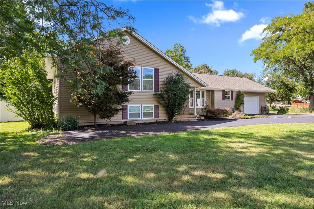 Welcome to your own private retreat right in the heart of Amherst, OH! This 3 bedroom, 2.5 bath split level home sits on over 2 acres, offering both space and convenience in a highly desirable location. Inside, you'll find an open concept kitchen, spacious primary suite and 2 full updated baths. Step outside and discover your personal paradise! A stunning in ground pool is the centerpiece of the backyard oasis, complete with an outdoor half bath, spacious patio, bar area, hot tub and plenty of room to entertain or unwind. You'll also love the large detached garage (extended in 2020) with an attached barn offering plenty of storage. The quiet, wooded backyard offers added privacy and a serene natural setting, making the most of the home's expansive 2 acre lot! The home features numerous updates for peace of mind, including a freshly resurfaced driveway (2024), water heater (2022), nature stone garage flooring (2021), roof (2018) and so much more! Don't miss the opportunity to call this exceptional property your new home!