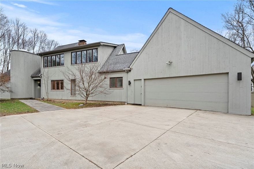 One-of-a-kind Pepper Pike contemporary cedar-sided home offering exceptional design, comfort, and connection to the outdoors.  You are greeted in a grand entrance foyer with soaring ceilings and crisp white walls.  The expansive sunken family room is a true showpiece, featuring cathedral beamed ceilings, a cozy fireplace, and a built-in wet bar—ideal for both relaxing and entertaining. The oversized galley-style kitchen is outfitted with high-end appliances and peninsula seating, seamlessly flowing into a warm and inviting hearth room with a second fireplace and additional gathering space.  Adjacent to the kitchen is a powder room for guests.  A bright first-floor office with large windows completes the main level, providing an inspiring workspace. Convenience is key with a 2-car attached garage equipped with a Tesla hookup.  Adjacent to the garage functional drop-zone area with a second powder room and direct exterior access.  A light-filled solarium ceiling provides breathtaking views as you ascend the staircase to the second floor—creating a truly unique architectural experience. Upstairs, you’ll find four generously sized bedrooms and three full bathrooms, including a luxurious primary suite with a private bath and walk-in closet. The suite also features a unique walk-up loft—perfect for a private gym, home office, or tranquil retreat.  The fully finished lower level expands your living space with a large recreation room and a state-of-the-art gym. Outdoor living is equally impressive, with two entertainer’s decks overlooking a fully fenced yard, private creek, and abundant green space—creating a peaceful, park-like setting.  With wonderful views from every room, plus major updates including a new HVAC system, new roof, and newer windows throughout, this home offers both beauty and peace of mind. Please contact the listing agent for a complete list of extensive property improvements.