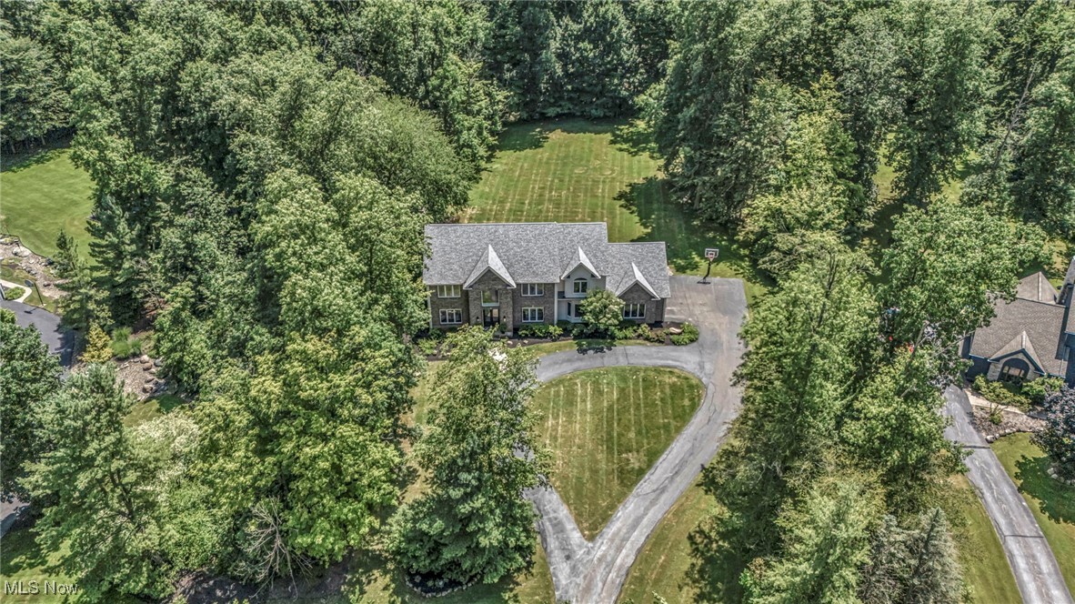 Discover this breathtaking & unparalleled living experience at 103 Champion Lane, a meticulously renovated exquisite colonial retreat nestled on a private three-acre wooded parcel in the heart of Chagrin Falls & the award winning Chagrin Falls School district. Boasting nearly $350k in recent renovations, this exceptional property located on a peaceful cul-de-sac offers the perfect blend of sophisticated design & natural serenity. Step inside & be captivated by nearly 6,000 square feet of masterfully redesigned living space, featuring 6 bedrooms & 5 bathrooms. Every detail of this custom top-to-bottom renovation has been thoughtfully considered, ensuring both luxury & comfort. The grand foyer welcomes you into a first floor designed for gracious living & entertaining. Here, you’ll find a dedicated office, an elegant living room, and a spacious two story great room. The chef's kitchen is a true highlight, boasting custom Wolf Artisan solid wood cabinetry crafted from American Maple, exquisite Quartzite stone countertops & backsplash, and all-new, top-of-the-line appliances. A convenient in-law suite with an ensuite bathroom completes the 1st level. The 2nd floor hosts four additional bedrooms and two full bathrooms, including the expansive master suite with its luxurious ensuite bathroom featuring Leida Bianca polished porcelain tile. The finished lower level expands your living options with a dedicated rec/theater room, an additional bedroom w/egress, & another full bathroom. Throughout the home, you’ll appreciate premium finishes such as Bali window treatments, natural hardwood floors, & more. This property is a private oasis. A beautifully refinished deck overlooks the expansive 3-acre parcel, providing an idyllic setting for outdoor enjoyment amidst the lush woods & natural surroundings. This stunning estate offers a rare opportunity to own a custom-renovated home with unparalleled privacy & natural beauty. Don’t miss your chance & come tour this stunning home!
