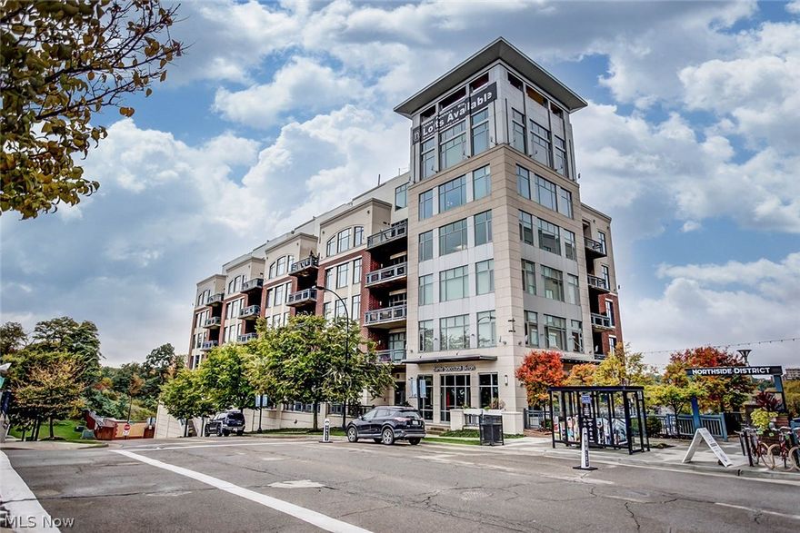 This stunning corner loft-style condo blends modern luxury with industrial charm, featuring expansive panoramic windows that fill the space with natural light and showcase breathtaking views of both the Downtown Akron skyline and the Cuyahoga Valley National Park. The open layout highlights exposed brick and concrete walls, granite countertops, stainless steel appliances, and a unique faux skylight in the kitchen. The spacious primary suite offers a private balcony, custom walk-in closet, and a beautiful en suite bath with a custom tile shower. Additional highlights include a second balcony off the living area, a guest bath near the main entry, and a laundry room with plenty of extra storage. Enjoy exceptional amenities such as a fitness center, concierge service, and private limo transportation—all within walking distance of the Northside Marketplace, local restaurants, shops, and entertainment—offering the perfect blend of urban living and upscale comfort.