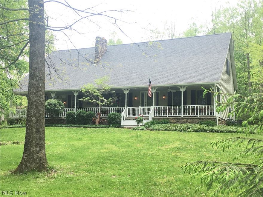 Vacation year round in this Custom Built home with 2,600+ sq. ft. of living area.  The setting is SPECTACULAR located on 4 wooded lots (1.6 ACRES) facing into the sunset with a full lake view after the leaves have fallen. An Inviting & Welcoming 64 x 8 covered Front Porch and Rear Wood Deck with built-ins provide plenty of space for relaxation overlooking the Glorious Private Yard both front & rear.. A circular concrete drive leads to a finished heated garage with hot/cold water and stairs directly to the basement. The property is professionally landscaped with perennial flowers, flowering trees and shrubs and bordered by a split rail and white vinyl fencing. A large shed opens at both ends for wonderful storage. Rooms are spacious with lofted ceilings, wood beams and 2 floor-to-ceiling stone fireplaces. True craftsmanship can be found throughout this well planned home. Kitchen has been upgraded with granite countertops, Stainless SteelKitchen Appliances, & reverse osmosis water treatm