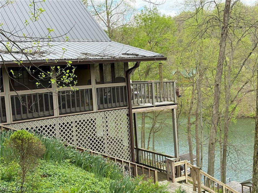 This LAKEFRONT home on TWO LOTS being sold Turkey AT UNDER $600,000 is quite an opportunity for an astute buyer.  This rustic home with the metal roof new in the fall of 2025features two bedrooms and two baths on the main floor, possibly a very large sleeping loft above that our looks the great room and kitchen. Master bedroom has a private bath. The kitchen has a breakfast bar plus a kitchen table area. There’s lots and lots of WINDOWS AND SLIDERS on the EAST-FACING LAKESIDE OF THE HOME.  This home is being sold, turn key, including everything even the John Deere gator and the pontoon boat. There are steps to from the house to the lake as well as a cement drive down to the lake for easy and comfort access to the lakefront where you’ll find a full dock with a boathouse. This home is located such that the boathouse is in an awake area. . This home is located such that the boathouse is in a No Wake area so swimming and fishing is certainly more comfortable and safer.  There is a 8 x 33’ deck off of the great room. Add the cement patio down below on the basement level. There also is a quiet inviting 19x 9 screened porch on the side of the home set among tall trees, and pine trees with beautiful views of the lake and this wonderful natural setting. The kitchen, great room and loft have very tall vaulted ceilings that are adorned with beautiful rustic wood planks. N