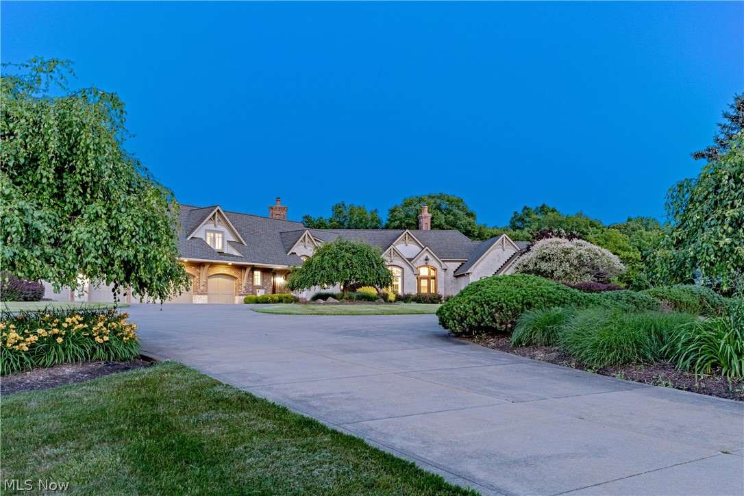 Situated on 27 breathtaking acres in Bath, this exceptional estate provides every imaginable amenity for today’s modern equestrian. With four pastures, an Amish-built 67’x180’ riding arena, and an 8-stall stable with a tack room and lounge, plus an additional 2-story carriage house, this French Country Estate leaves nothing to be desired. Originally built by Tony Paskevich in 2001, with an elevator connecting all three floors, the sprawling main house features soaring ceilings, elegant features, and imported finishes including countertops from the Isle of Malta and an imported custom La Cornue range and reclaimed mantel from a French chateau. From the great room with distressed hickory flooring to the exquisite first-floor bedroom suite designed for relaxation and comfort, each element of the home was hand-selected with the finest attention to detail and care. The kitchen is a delightful mixture of reclaimed antique finishes and contemporary amenities, including the custom Amish-built cabinetry, reclaimed sink and backsplash, and heated limestone flooring. Off of the kitchen, the sunny breakfast nook features a fireplace, imported lighting, and French doors that open to one of the home’s many covered patios. The first-floor primary wing includes a fireplace, a luxurious en-suite bathroom with two walk-in closets, and a private dressing room that could also be used as an office. Upstairs, there are three bedroom suites and a second kitchen, perfect for an in-law or guest suite. The full lower level is just waiting to be finished into an incredible home fitness center. Outside, the pristine, pastoral setting is equally suited for relaxation and recreation. Three out of four pastures are equipped with Nelson Automatic Horse Waterers, and the property connects to the 400+ acre Bath Nature Preserve for easy access to local bridle trails.