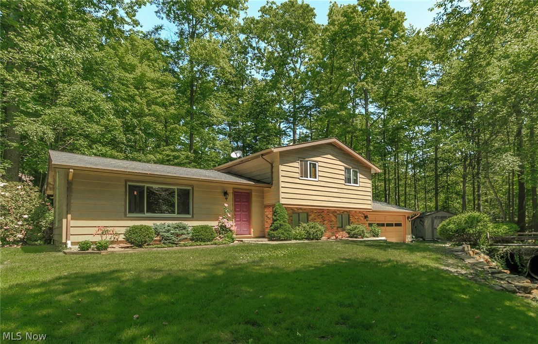 Situated on 1.43 park-like acres you will find this three bedroom, two full bath meticulously cared for split level home. Kitchen features ceramic tile flooring, center island, built in planning center and skylights. Living room windows allow for natural sunlight to fill the room. Relax and unwind with the 100" front projection home theater with 7.1 surround sound in the lower level family room which has been completely renovated and features contemporary details such as crown moulding, custom lighting and a fireplace mantle and surround. Cabinets were installed in the utility room for added storage. Updates include a new septic system (2004), updated electrical service (2009), insulated attic (2015) and a new water softener and pressure tank (2014). Hot water tank is only two years old and all upstairs windows were replaced approximately four years ago (Pella - Fiberglass). Drywall and wire shelving added to the garage (2008), the lower level was completely renovated including electri