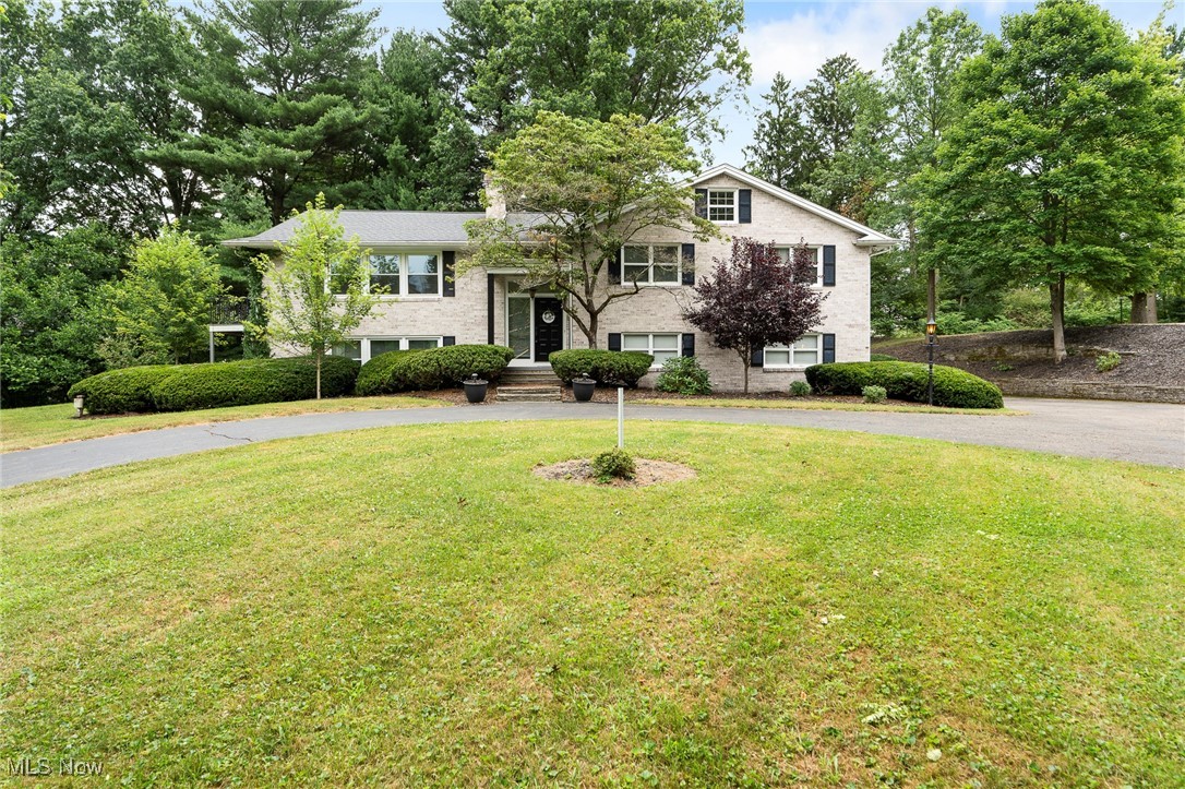 Do you love to entertain? Then this home is perfect for you! Absoulely stunning and well-kept bi-level, located in the heart of the Hills and Dales community! This move-in ready home boasts comfort and charm throughout. Enter through the front door to be greeted by large & open foyer. Custom railings and Luxury vinyl floors lead up to main foyer area. Oversized family room with row of windows and large glass slider allow for ample light throughout this home. Open and free flowing walk into large dining room with custom light fixture. Gorgeous custom kitchen with recessed lighting, granite countertops, and custom cabinets. Backsplash perfectly placed to complement the kitchen space and stainless steel appliances. Main floor laundry with utility tub located off kitchen. Powder room (1/2 bath) off laundry has access to private family room with brick fireplace, sliding glass door, accent beams, and built-in bookshelves. Sliding glass door off kitchen leads to private deck and patio area, with fire pit and lots of space for entertaining guests or relaxing on a summer night. 3 large bedrooms with large closets and ceiling fans. Primary owners suite has private bath and wall of glass block windows. Journey back downstairs past your custom chandler to the 3rd full bathroom. Large bar space with accent beams in the lower level with additional full kitchen, full bath, and living area with your third fireplace complete with plenty of natural light. This lovely home is situated on just under 2 acres & can be your dream home! 3 car garage, newer roof and brick exterior complete this beautiful house. Schedule your private tour today before this well-kept beauty is SOLD!