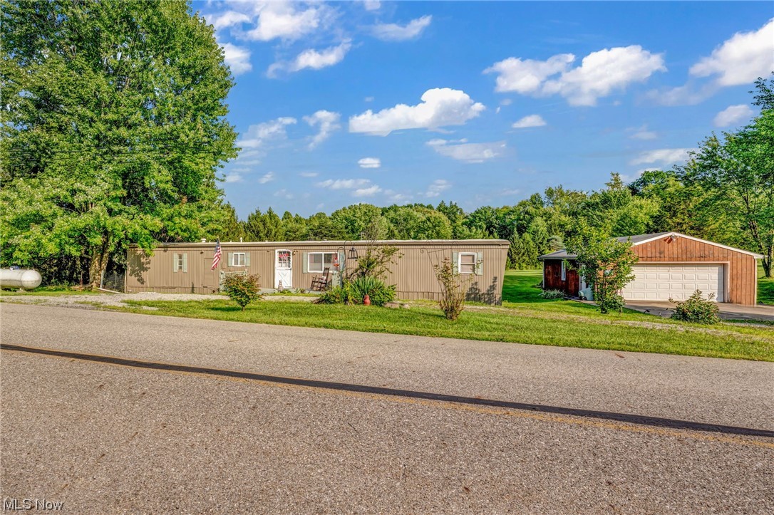Experience countryside living with this charming mobile home on 1.60 acres. The master suite offers its own bathroom and expansive closet, while an additional bedroom and bathroom provide space for guests. Upgrades include new flooring, plumbing replacements, and newer appliances, ensuring modern comfort. Stay cozy with forced air propane heating, and enjoy the convenience of central air conditioning. Outside, a large deck invites relaxation, while a 2-car detached garage, shed, and ample outdoor space cater to storage and hobbies. This move-in-ready home includes all appliances - microwave, range, refrigerator, washer, and dryer. Schedule a viewing today and seize the opportunity to own real property.