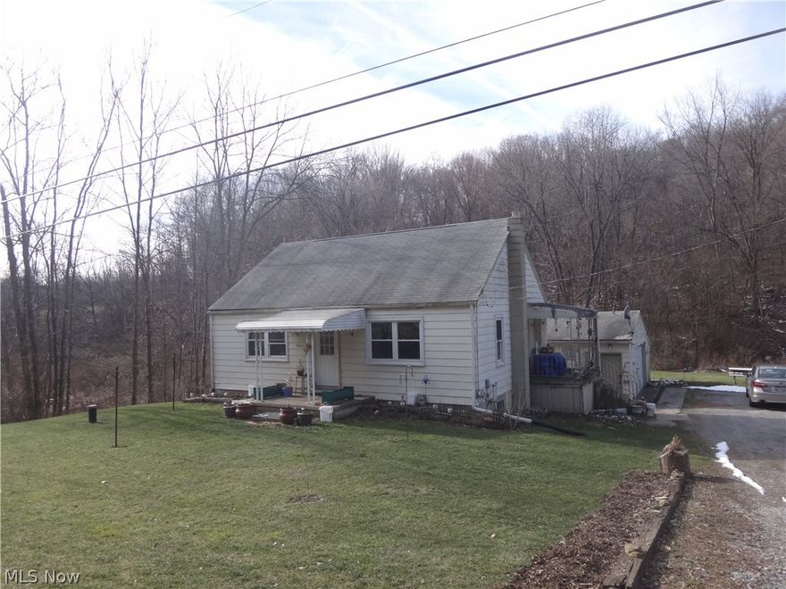 POSSIBLE LAND CONTRACT! Are you just starting out or wanting to downsize?  This may be the right home for you!  This aluminum sided ranch features an all applianced eat-in, updated kitchen, living room, two bedrooms and an updated full bath all on one floor.  Current owner is using the second bedroom for a first floor laundry room, but could be changed back to a bedroom. Hardwood floors under newer carpeting.  Full walk-out basement.  Forced air oil furnace, hot water tank, water softener, updated electrical and plumbing in basement.  Vinyl windows approx. 9 yrs. old.  Newer roof on back side of home.  Two car detached garage with lean to for additional storage.  Garage door and opener less than 4 yrs. old.  All of this sitting on over an acre of ground located in Beaver Local School District.  Small creek to the rear of the property.  Shared driveway.