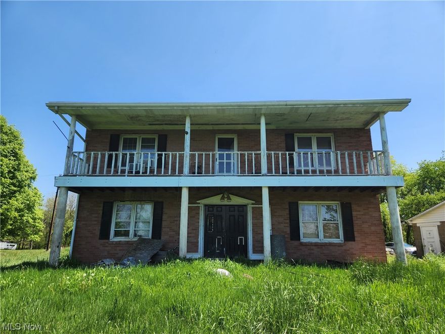 AMAZING OPPORTUNITY AWAITS! Picturesque country setting on 5.2 acres featuring long private drive set far off the road & overlooking a beautiful hillside, close to Edison School, Clay Lick & Cedar Lick Creeks, & Quaker Ridge Nature trails. Two story Federal Colonial brick home boasts 4 bedrooms each with hardwood flooring. The primary bedroom exits to a balcony to enjoy your morning coffee or unwind with your evening wine. Large living room features wood burning stove. Two full baths have started renovations with new: LVT flooring, toilets, the 1st floor bath features a step in shower, the 2nd floor bath features tub/shower combo, new granite double sink vanity, & wall heater. Brand new but not installed will come with home: windows for the entire home & new luxury vinyl tile flooring for 1st floor. Additional updates include 200amp electric box, new well pump, hot water tank & softener all 2023.  Property includes: Two car cinder block garage, in need of roof & doors, Two chainlink do
