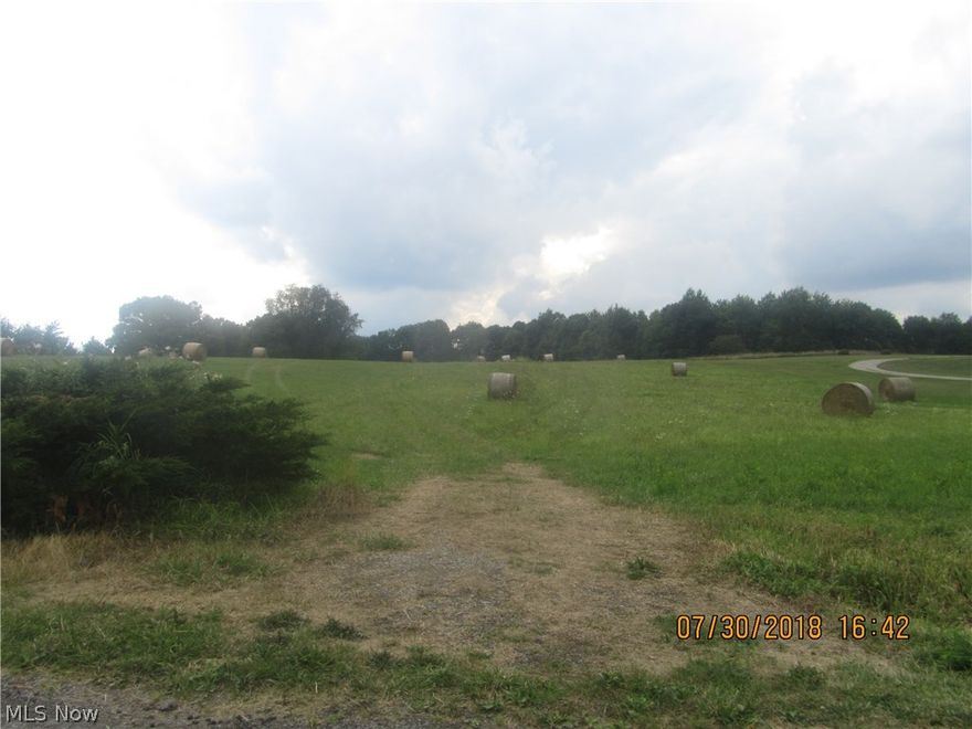 Unrestricted 6.49 acre building lot with septic system already in place.  Mostly cleared high ground ready for your new home!    Recently hay cut and baled, driveway base is in under the grass.  Country woods and field view from this high laying lot in an area of well kept homes.     Lot is app 315' x  968' and is mostly rectangular in shape, with the exception of road frontage that follows the curvature of the road.