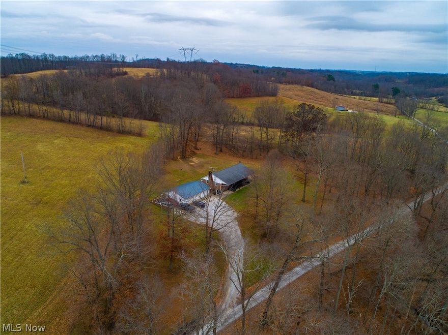 Spacious All Brick ranch home on 1.5 private wooded acres.  Move in ready with many upgrades.  Enjoy the country views from your front covered porch and your walk out patios.  Updated kitchen supplying a massive island with seating, corian counters, stone backsplash and floor, stainless steel appliances.  Open floor plan with kitchen, living, dining, foyer with a stone wood burning fireplace.  3 bedrooms upstairs.  The huge 26x34 Family/entertaining area features its own brick fireplace with a walk out to another patio area.  An additional 2 bedrooms with a another room used as a walk-in closet will be perfect for those needing 5-6 bedrooms.   The large laundry room complete with a full bath completes the downstairs. The large 3 bay detached garage is conveniently located with a metal roof.  This home is surrounded by farm pasture fields located less than one mile from Public Hunting and Fishing land.  Newer Hot tub will convey with the property.  This property has audio and video surv