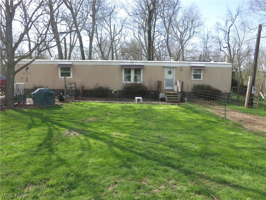 River lot with nice 14 X70 manufactured home, new front windows, new flooring and other improvements, sets on full concrete pad.