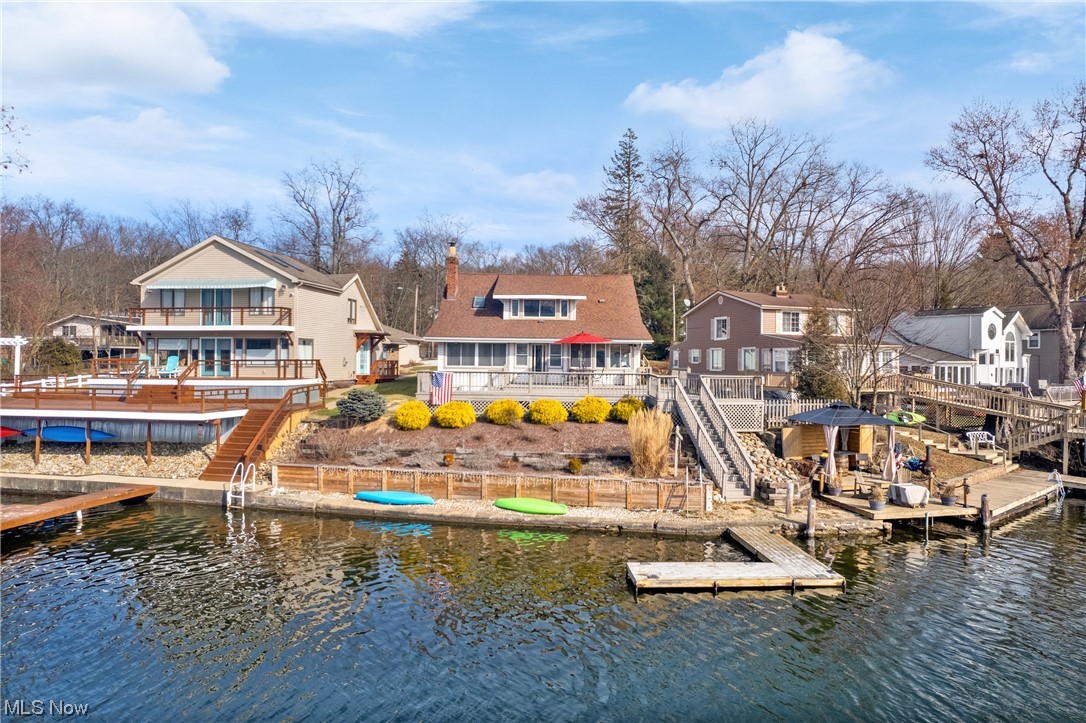 Charismatic west facing lakefront with 80 feet of lake frontage on the Main Chain of Portage Lakes West Reservoir. Perfect long lasting sunset views! Four bedrooms with two on the main floor and two full completely remodeled bathrooms. Gorgeous remodeled kitchen including granite countertops, stainless steel appliances with lots of new cabinetry for tons of storage. Also includes breakfast bar and dry bar area. Dining room opens to living room with gas fireplace and two heated sunrooms with walls of windows for lakeviews. Refinished original hardwood and some new hardwood to match. New carpet throughout. Second floor offers large master bedroom with even more lakeviews. Fabulous master bath remodeled including jetted garden tub, double vanity and separate shower. Jack and Jill style with door to fourth bedroom. Enormous deck for entertainment with steps to side teired tiki style deck lakeside and docks. Nicely landscaped and gently sloping to lake. Two plus detached garage. LOTS of parking on site for all of your guests! Short walk to Lakeside Park pickleball court. Only three homes on the entire dead end street. New roof 2018. New well pump. New HAVC. Make this charming and adorable lakefront yours in time for boating season!