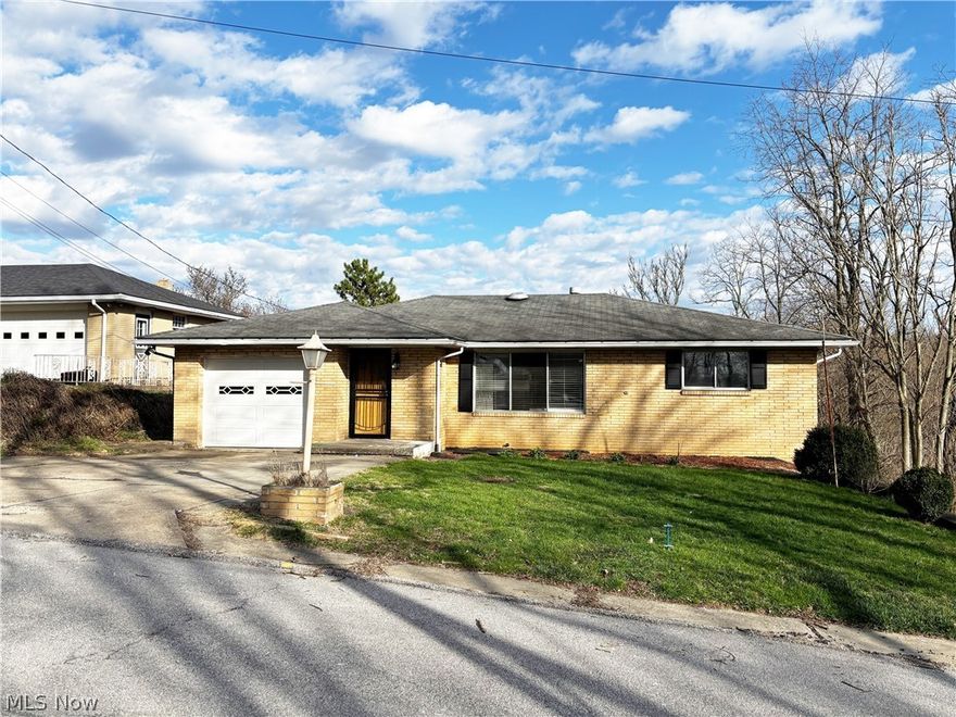 Welcome to this well-situated 3 bedroom, 2 full bathroom home in the heart of Weirton, WV, offering a thoughtful blend of living space, convenience, and entertaining potential. This brick ranch-style residence features an inviting eat-in dining room with an attached deck, ideal for outdoor gatherings and everyday enjoyment. The attached 1-car garage includes attic access via pull-down stairs, adding practical storage options.  New hot water tank installed in 2026.
The lower level boasts a large recreation room with a built-in bar, an additional versatile room, and a dedicated laundry area, all anchored by walk-out basement access — perfect for indoor/outdoor flow and future customization. With approximately 1,260 sq ft of living space, this residence provides functional living areas and the opportunity to tailor updates to your taste.  Also, a second adjacent lot provides you with an acre +/- of total land.  
Located in the established 26062 ZIP code of Weirton, this home enjoys proximity to shopping, dining, parks, schools, and major commuting routes.  Don’t miss your chance to own a home with character, functional space, and the potential to make it your own.