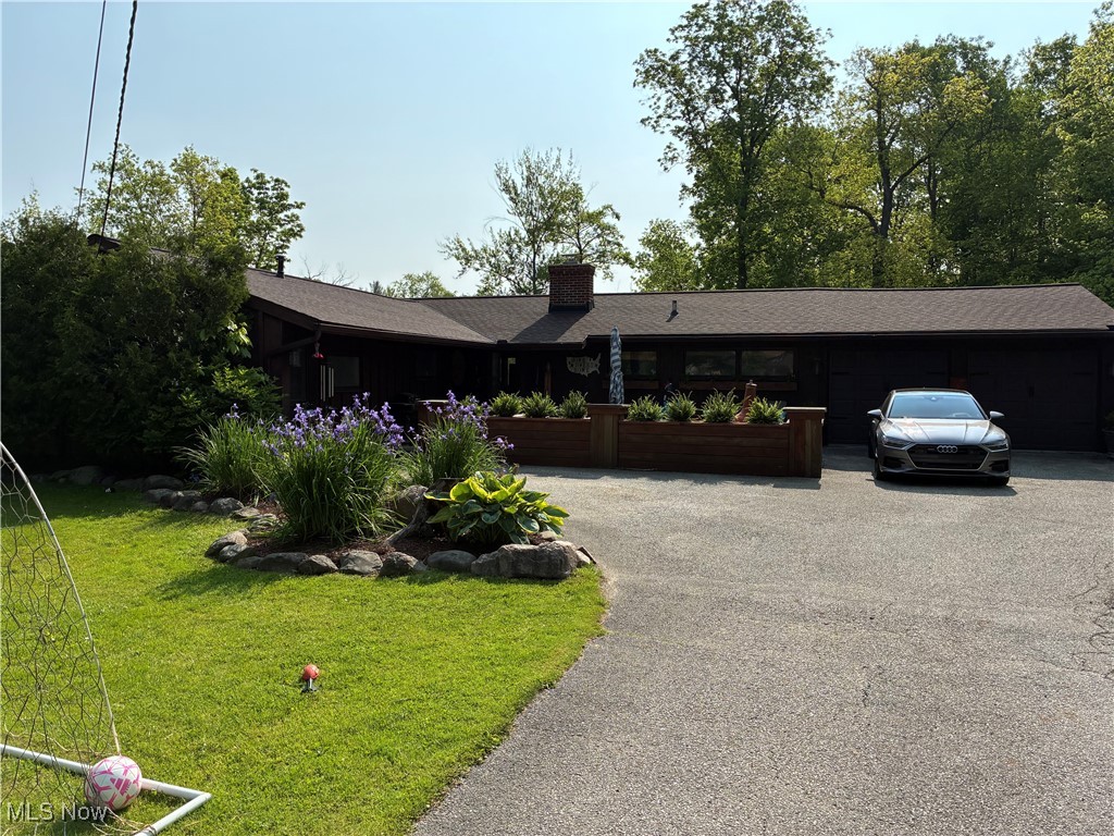 Nestled in a vibrant neighborhood just steps from the Geauga Park District and less than a mile from the highly acclaimed West Geauga School District, this beautiful open-concept ranch offers the perfect blend of comfort, convenience, and modern living. With three spacious bedrooms, two bathrooms, and a three-car garage, the home is ideal for families or couples seeking a stylish and functional retreat. The bright, open floor plan flows seamlessly into a stunning kitchen featuring high-end, slow-close cabinetry, stainless steel appliances, and an oversized island with built-in seating—perfect for entertaining and everyday gatherings. Outdoor living is elevated with a fully fenced backyard, a dog door providing direct access from the exterior into the garage, and a large, finished, screened-in porch that opens to a deck and pool area. A fully heated and air-conditioned shed, previously used as a golf simulator space, offers high-speed internet and endless possibilities—transform it into a home office, gym, spa, movie theater, or entertainment hub. Additional upgrades include new ductwork, furnace, and air conditioning system; a new roof and chimney; a new septic system (approximately five years old); and a new water softener and pressure tank. The large front patio features custom wood planter boxes for added privacy, while the backyard boasts a perfect firepit area for cozy evenings. This rare gem combines style, functionality, and an unbeatable location. Whether you're hosting friends, working remotely, or enjoying your private backyard oasis, this dream ranch home has it all—modern upgrades, proximity to nature, and top-rated schools just minutes away.