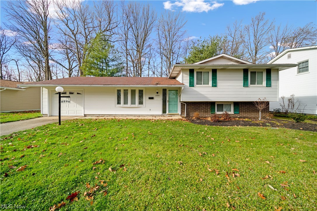 Welcome to this beautiful three bedroom one and a half bath split level in Mentor. Walk in to a completely remodeled main floor.
Living room- freshly painted, new lighting, new flooring in 2021. The kitchen was opened up to the dining area and remodeled- new cabinets, appliances, lighting, manufactured quartz counter tops, and flooring (2021). Upstairs you will find three bedrooms all with hardwood flooring and a full bath. The lower level is partially finished, this space makes a great family room or rec room and features a half bath. Head outside to the large deck perfect for entertaining or relaxing. The deck features built in bench seating and a hot tub.