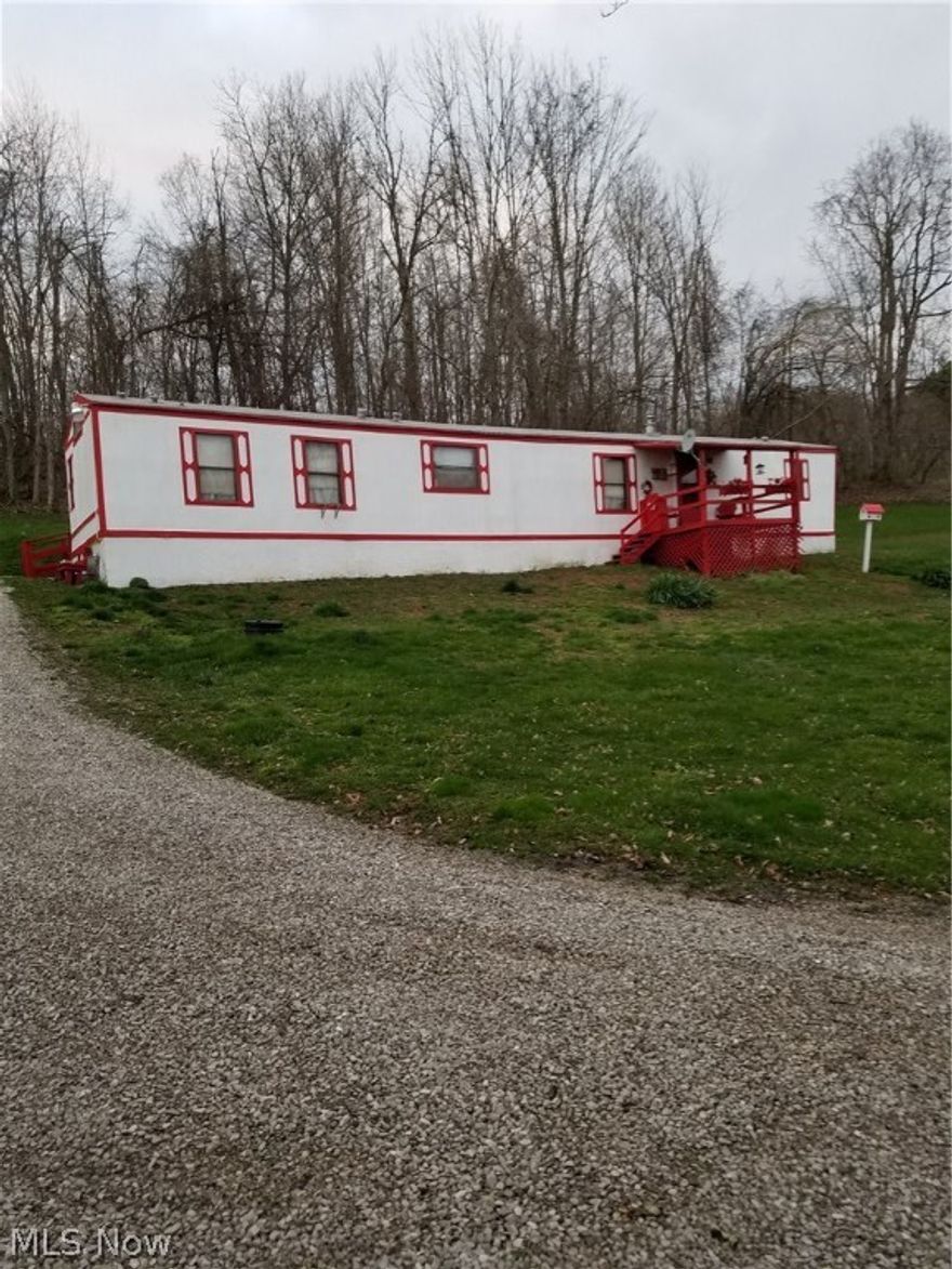 A little peace and quiet on 2.32 acres in Noble County. Very well Maintained 14x70 mobile home with tip out for living and dining rooms. Considered real estate on concrete pads and anchored with steel cables. This 3 BR, 2 bath home has an open floor plan with kitchen island that seats 4.  The furnace is only 6 yrs old and there is a 3200 BTU wall unit heater that will heat whole home. Newer roof in 2016, new floors in dining/living room extension. New water pump in 2018. Outside painted 2017. 1500 Gallon cistern. All appliances and some furniture stay. Dryer needs new belt. Riding lawn mower also stays! There are 2 storage buildings (8x10 and 8x16) and 2 car carport. Covered front porch and enclosed back porch. Schedule your showing for this little piece of country living only a few minutes from interstate 77, today!