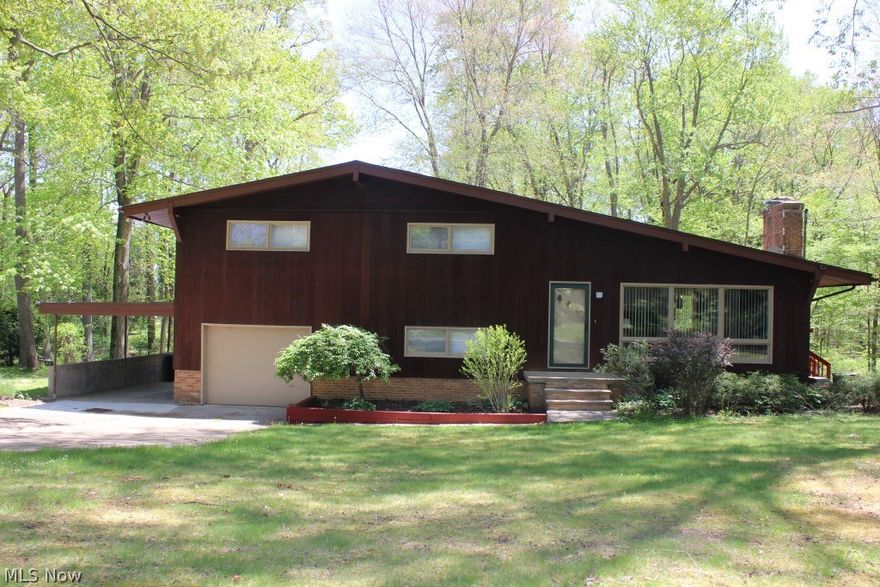 Contemporary 4 level split custom built with 3 bedrooms, 2.5 baths, approx. 2292SF on cul de sac & includes extra lot totaling 1.39 acres* Open floor plan with vaulted ceilings & oversized windows* Vaulted great room with brick wood burning fireplace, window wall & laminate floor* Retro eat in kitchen, vaulted with built in refrigerator, oven, burner top, dishwasher, breakfast bar, built in cabinet wall & access door to deck* Upper level with master bedroom with private bath & wood floor* 2 additional bedrooms with wood floors, guest bath & open loft/office overlooking great room* Lower level with walk out rec room, half bath (can be converted to full bath), laundry & access to 3 season sun room* Sun room wrapped with windows/sliders accessing deck, built in cabinets & fan* Basement level with partial kitchen & access dootral r to back yard* 1 car attached garage plus carport* Updates within last 6 months include but not limited to- shingles (single layer), septic system, hot water hea