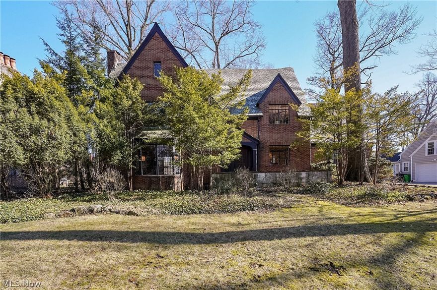 Every home tells a story, and this timeless Silver Lake Tudor Revival tells one rooted in architecture & local history. Designed in 1939 by Akron architect Melville Peck for Mabel Graham, who was instrumental in founding the Akron Symphony Orchestra, this 4 bedroom, 3.5 bath brick residence is rich in character, distinctive period craftsmanship & enduring detail. Arched doorway w solid wood front door & leaded glass insert creates a warm, lasting first impression. Original hardwood floors carry throughout the home & into the main living room, where the orig fireplace showcases high-relief Dickensian story tiles, an extraordinary period detail rarely found today. Large leaded glass windows w storybook-inspired detailing bring in abundant natural light. Orig oak built-ins offer practical storage while preserving the craftsmanship of the era. Kitchen offers a clean, timeless look w white cabinetry, granite counters, SS apps & island for add'l prep & storage space. Sunlit corner breakfast nook sits beside an intricate tile wall feats pieces collected from around the world during the orig owner’s career as an int'l figure skating judge. Dining room & 1/2 bath complete the first floor. Second floor master suite feats dedicated dressing hallway w multiple paneled closet doors, leading to detailed mosaic tilework in bathroom, hand painted murals & OG HW floors. Two more generously sized bedrooms w OG HW floors, hand painted murals, hallway built-ins & an updated bath, feats orig decorative tile insert. Third floor bonus area feats soaring ceilings, large closet & office. Lower level showcases a pub-style setting w orig wet bar, ample ent. space, laundry & add'l storage. Above the two car garage, private guest suite feats full bath & built-ins for storage. Ext hi-lights inc spacious back yard, sunroom, patio, and playset. Enjoy the exclusive Silver Lake membership privileges w lake access, boating, fishing & events. Convenient location near amenities & local conveniences.