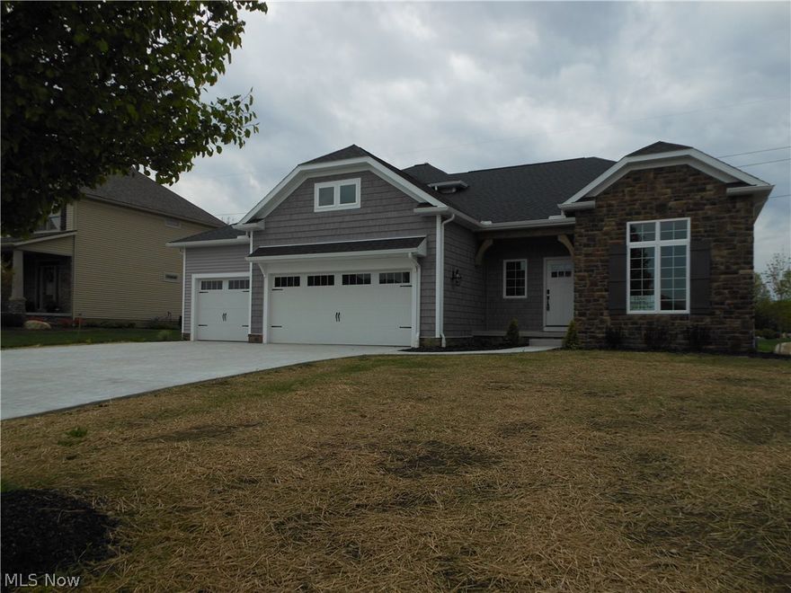 The beautiful stone and shake exterior suggests both style and easy maintenance. Open floor plan, large chef's kitchen, showcasing Amish custom cabinets and granite counter tops, perfect for both family time and grown up entertaining. 33'X17' area with additional space for dining. A large fireplace anchors the great room and wood beams and warm, sustainable bamboo flooring in the kitchen, dining room and great room lend elegance to the entire space. A charming covered porch at the rear offers a peaceful retreat to enjoy at the end of a busy day. The master suite is an oasis with a 12X9 walk in closet complete with a custom shelving system. The bath features a double vanity and custom shower, and the master bedroom is beautifully accented with a dramatic coffered ceiling. The first floor laundry offers easy access to and from the master suite and storage is in abundance, especially the oversized 10X6 pantry off the kitchen. A second bedroom/den and full bath offer both function for the