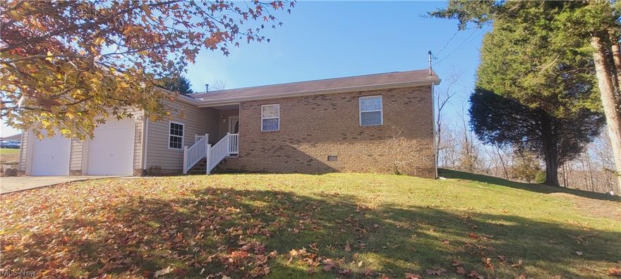 Ready and Waiting. Located near WVU-P and I-77 just 5 minutes easy access and ready for you! House has nice open great room with vaulted ceiling, open dining and kitchen area.  You will have 200 amp electric and oversized double garage with a large attached parking pad-great to park & store your RV or for additional parking. Off the great room you will enjoy the nice 12x14 screened porch overlooking the rear woods. Home has newer laminate in main living areas. This is the perfect 1-level home for new beginnings or for downsizing.