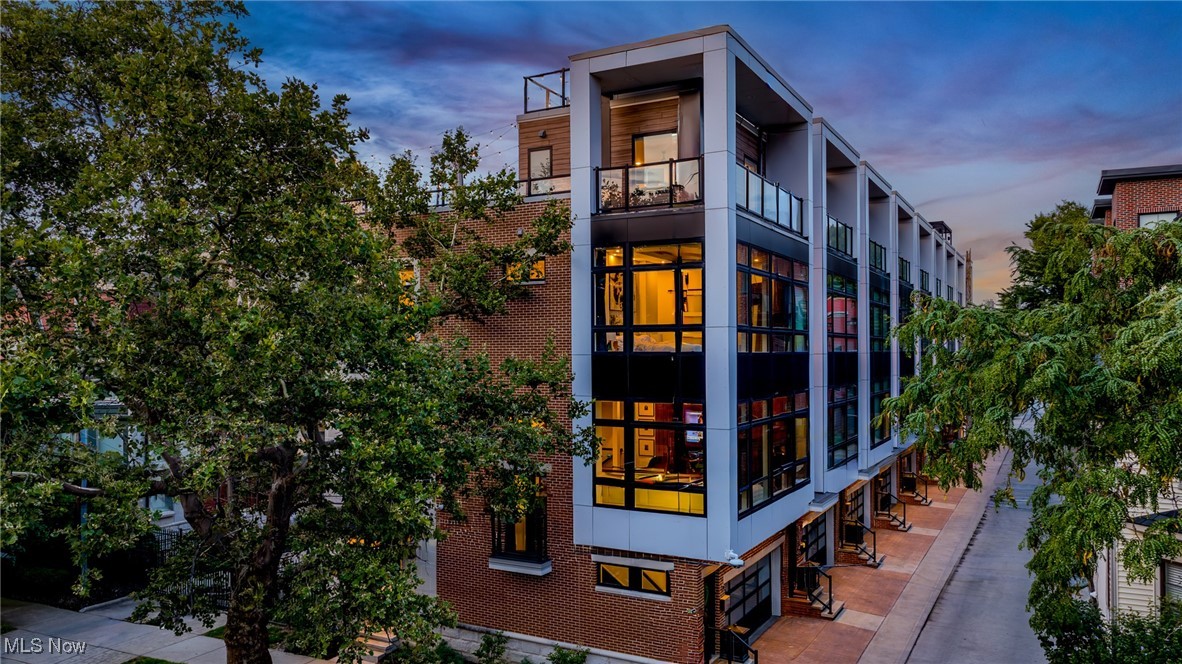 Modern Luxury Meets Unmatched Views in Historic Ohio City in this Vine Court END Unit Townhome! This stunning, like-new modern townhome community is situated in the heart of Ohio City's vibrant and walkable Hingetown neighborhood! This rare end unit offers a fifth-floor rooftop buildout with 360° panoramic views of the Cleveland skyline and Lake Erie. Step inside and be wowed by high-end designer finishes, cutting-edge smart-home technology, and abundant natural light accentuated by custom motorized blinds. The striking black walnut fireplace wall, crafted by a local artist, anchors the main living space which flows effortlessly into the gourmet kitchen featuring a waterfall quartz island, sleek cabinetry, and premium appliances. The home features spacious bedrooms with custom walk-in closets and modern bathrooms with beautifully worked tilework. The first floor room is ideal for a home office, gym, creative studio... or golf simulator!! Current owner has it outfitted as a high-end golf simulator room! Equipment sold separately from the sale. Double doors take you to a private turfed backyard which is a perfect spot for relaxation or pet enjoyment. The illusion-style staircases take one up to a top floor level with half bathroom, views and supplemental Mini split system for maximum comfort. Step out to the real showstopper of the property. A wraparound deck leads to a double-terrace rooftop oasis complete with a 6-person luxury hot tub, outdoor TV, Trex decking and the most unforgettable skyline and lake views around! This smart home boasts Cat 5 wiring throughout and iPad controls of blinds, climate, lights, locks and more. Enjoy the charm of historic homes and tree-lined sidewalks while being just 5 minutes from downtown Cleveland, a quick stroll to top-tier coffee shops, boutiques, and restaurants, and a few blocks from the Towpath Trail leading straight to Edgewater Park. FULL City of Cleveland tax abatement through 2034!