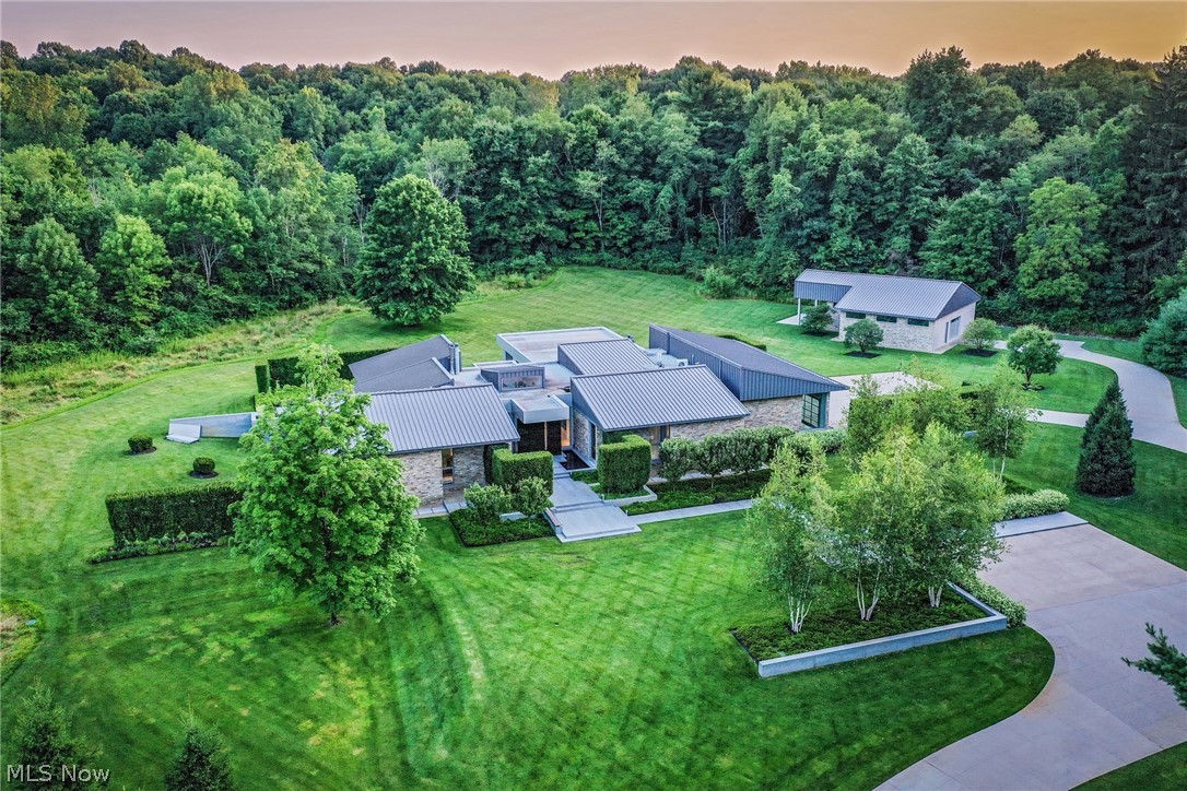Tucked away at the end of a gated drive, this magnificent contemporary estate rests on 8.5 acres of manicured grounds surrounded by parkland. Glass walls throughout the home frame picture perfect views of the grounds, a perfectly cultivated sanctuary designed by David Thorne. Floating stepping stones lead you to the front entrance, where the walnut front door pivots open to reveal the interior. Every element was consciously designed to promote tranquility, from the sleek ebony wood panels to the sliding doors which seamlessly conceal each bedroom suite. The open living area includes a Valcucine kitchen, two fireplaces, a temperature controlled wine display, and folding doors that open to the outdoor entertaining area. Here, you will find a covered patio with phantom screens, an outdoor kitchen, two firepits, and a stainless steel whirlpool jacuzzi. The owner’s suite includes an elegant en-suite dressing room and bath with a soaking tub, a steam shower, and a breathtaking geode accent w