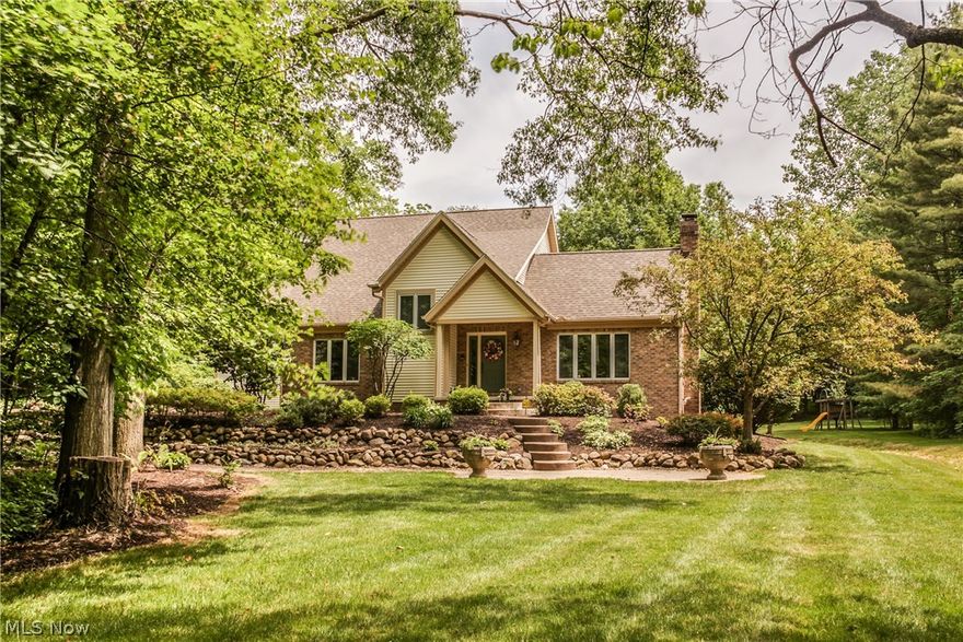 A private winding road takes you back to this heavily wooded lot and secluded park like setting for this custom built home. The home was built with quality craftsmanship and sits on 2 1/2 acres, with terraced gardens. As you enter the home you feel a sense of style and elegance. The formal living room boasts a brick floor to ceiling fireplace to warm the winter nights, while the formal dining room sparkles with hard wood floors, and crown molding. Perfect for entertaining or everyday living is the spacious kitchen, with center island and state-of-the-art stainless steel appliances. The kitchen has also been updated with granite counter tops, travertine floors. Impressive French doors open to a large family room with wet bar, as well as a full wall of windows. An atrium door leads to the deck with hot tub and your private view of nature. The first floor master suite welcomes you with open elegance and entices you with a master spa... a Jacuzzi tub and separate shower, a customized walk
