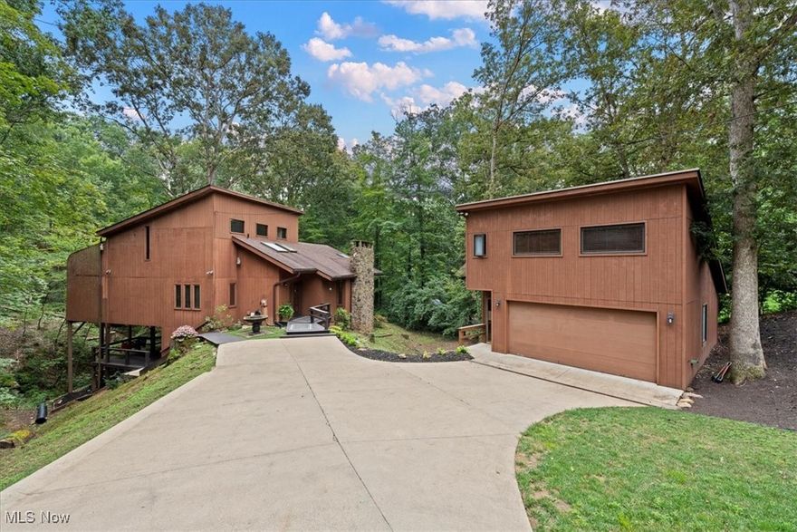 Contemporary custom built home, situated in quiet cul-de-sac offers open floor plan & lifestyle of tranquility & charm. Entering the home you are greeted by entry offering guest closet & hardwood flooring opening into the Great Room that invites you to relax w/a roaring fire (stone wall WBFP gas start) & cozy blankets while oversized windows frame peaceful views and is open to the beautiful, newer kitchen (6 yrs old) w/black Granite counter tops, beautiful cabinetry, appliances (stainless steel dishwasher, electric range, drawer microwave in island, refrigerator), deep sink w/corner window wall, tile flooring, pantry, island w/Granite counter top, stone sides, cabinetry & accent lighting for dining or enjoying your morning coffee, skylights, desk area & door to rear decking (2 levels)  for private, outdoor living space that’s immersed into sights & sounds of nature. Off the kitchen is private, centrally located laundry room. The living room offers great wall space, crown molding & is open to the dining room w/atrium overlooking woods and babbling brook.  A bedroom is located on the main level or would make a home office with abundance of natural lighting.  A convenient, updated, half bath completes this floor.  An open set of floating stairs with all new handrail leads you to the 2nd floor offering huge private master suite w/cathedral ceiling, atrium view, grand sized walk-in closet & luxurious all new full bath with cathedral ceiling and natural light (bath completed Fall 2025).  The upper floor is a total owners private retreat.  Open floating stairs w/all new handrail leads you to the lower level featuring study/library w/built-in shelving, 2 bedrooms, updated full bath with shower and mud room w/door to large lower decking that is easily accessible from the upper deck and would be perfect for a hot tub for relaxing.  This peaceful retreat offers everything you need to disconnect and recharge…peaceful, private setting designed to refresh your soul.  A Must See!