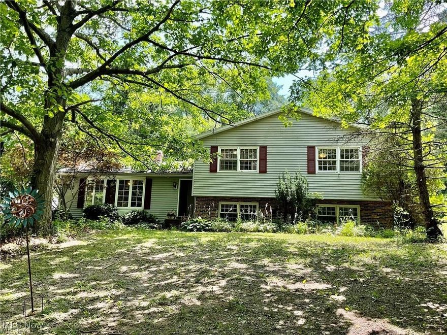 A tranquil escape on 3.64 acre wooded/mature trees with creek. The home sits over 100' off of the street. 4 bedrooms and 3 full bathrooms this oversized split level home is ready for you to make it your own! Newer roof and hot water tank are recent updates. Living Room with Bay window and window seat had carpet installed in 2023 also features a brick woodburning Kodiac style fireplace. All 4 bedrooms have parquet flooring. There is a on suite full bath off master and a walk in closet. There is a guest bath featuring a jacuzzi tub. The lower level was once an in law suite with an adjacent full bath near laundry area. There is also a huge family room. Eat in kitchen with dining room brings a lot of country charm. Appliances stay. Spacious basement has shelving and room for a home workshop. 2-1/2 car garage with door openers and 220 wiring for an electric car or welding. Fenced in back yard area. Located near Medina and freeways. Second owner. Call today