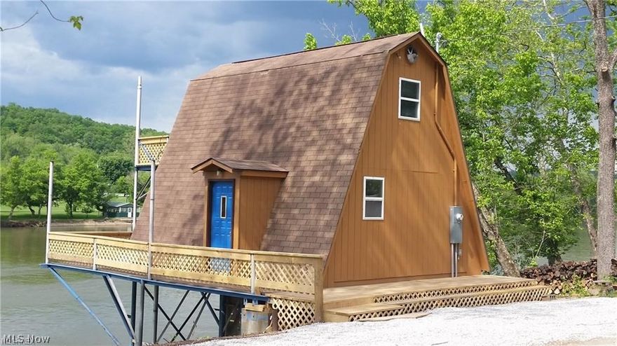 T111 A-Frame with a dock, a deck, and a balcony on the Muskingum River north of the Lowell dam. Beautiful setting with an empty lot across the road for parking or building. Gravel parking area along side of the road. Steel beams are core of engineer beams with appropriate variances acquired.