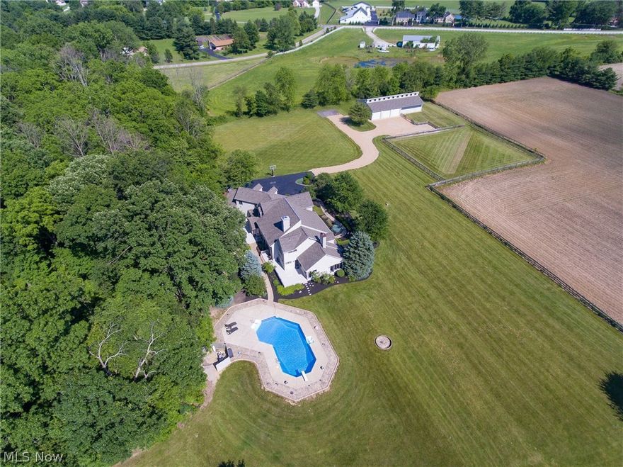 You'll be the envy of your neighbors with the manicured landscaping surrounding this 8,250+ SF home on 26+ acres. Features include 6 bedrooms, 5 bathrooms, captivating great room, master suite with sitting room and office, and walk-in closet. The distinguished dining room, captivating great room, and custom kitchen with breakfast bar for on-the-go meals! This just begins to describe this impressive property. There is an enormous room that could be used as a college students quarters, mother in law suite, or even plenty of space to let out of town family stay with you! The Horse barn with stables make for a great equestrian estate! The pond and sparkling inground swimming pool are two more spectacular features of this expansive property!