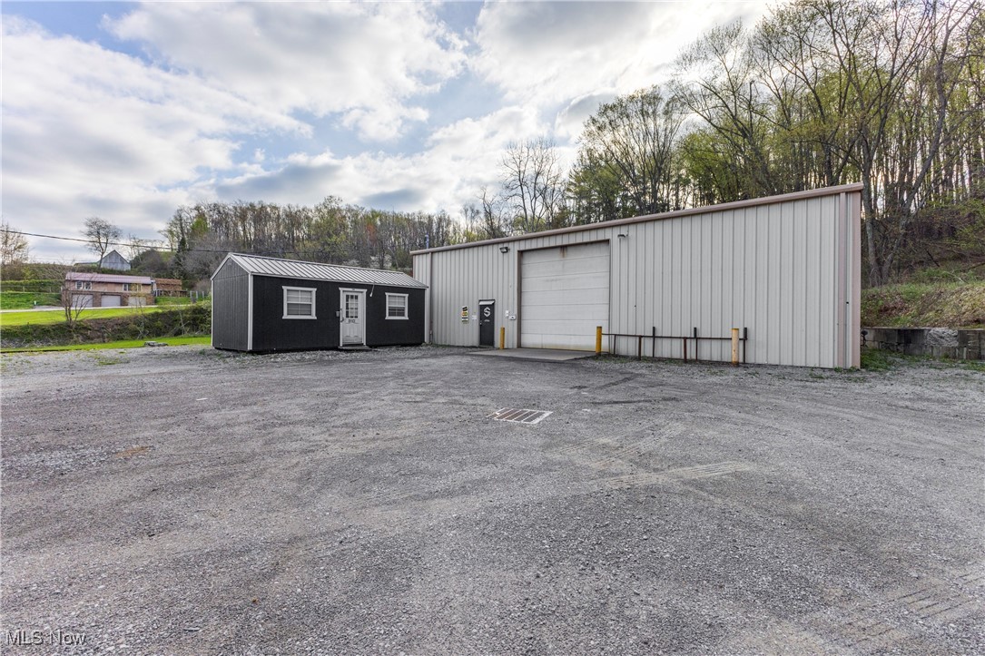 Excellent opportunity along the tri-state area! Conveniently located just minutes from the Pennsylvania, West Virginia, and Ohio borders, and tucked right off State Route 30, this versatile property is a rare find. Situated on approximately ½ acre, this 2,400 sq ft steel building, built in 2008, offers endless potential. The space features a large metal garage equipped with an overhead crane, bathroom, storage areas, and a dedicated office space — ideal for business operations, equipment storage, or workshop use. A detached shed is also included, offering even more flexibility for storage or workspace needs. Zoned 044 - Light Manufacturing in Hancock County, WV, this property is well-suited for a wide range of permitted uses, including light industrial manufacturing, fabrication, warehousing, distribution, storage facilities, and similar business operations. Light Manufacturing zoning typically supports businesses that do not produce significant noise, odor, or environmental impacts — making it a versatile choice for many commercial or industrial users. Whether you're looking to expand your operations, store equipment, or create a new base for your business, this property checks all the boxes. With easy highway access, a usable layout, and a strategic location, it’s a must-see. Don't miss out on this excellent investment opportunity in a growing, high-demand area!