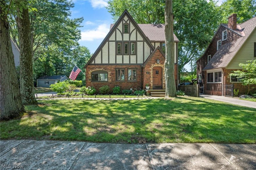 Classic three story Tudor style home with a finished basement located on oversized property with a spacious 2 car garage, deck and a firepit area. This home tells its story with its curb appeal, mature trees that surround the property, and its beautifully detailed door to welcome you in. Inside the home, original charm and character can be seen from every room. Some of these features include hardwood flooring, crown molding, arched walkways, and a gas fireplace in the living room. The formal dining room comes with built-ins and French doors that lead to a spacious deck with a peaceful and garden oasis backyard. The kitchen features newer appliances that are all included and a breakfast nook complete the tour on the first floor. The finished third level attic and finished basement with decorative fireplace and glass block windows offer additional living space. RECENT updates to the home include: complete tear-off and roof replacement (2022), basement waterproofing with sump pump added (2020), replaced vinyl siding, gutters, and fascia boards on the home (2022), enclosed patio with custom glass windows (2021), fire pit area landscaped (2021), repainted majority of the interior (2020) and much more... INLCUDED are all kitchen appliances, GE, DeLonghi, and Magnavox AC units, Ring Doorbell Camera, and a 1-year home warranty. This unique property provides owners benefit to utilizing both Cleveland Hts and South Euclid amenities such as recreation facilities, pools and community centers. Conveniently located near I-271, I-90 with easy access to Downtown Cleveland, Cleveland Clinic Main Campus, University Circle, parks, shopping, and restaurants. This home is a must see and a one of a kind gem!