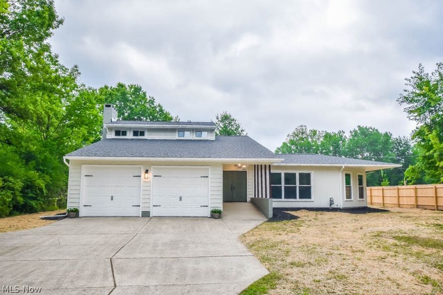 This absolutely stunning contemporary home has been fully remodeled with high-end upgrades throughout! The foyer entry has a large coat closet and open view into the step down living room with a wood burning fireplace accented by a tiled hearth as the focal point of the room. Enjoy your new kitchen space featuring quartz countertops, stainless steel appliances, an expansive center island with a breakfast bar plus a dining area with floor to ceiling windows that fill the space with natural light. A modern 1st floor laundry and guest bath are tucked in the hall leading to the owner's retreat complete with a walk-in closet and a spa inspired bathroom with an upscale double vanity and gorgeous tiled shower with dual shower heads. The generous family room adds a relaxing space enhanced by a shiplap accent wall and sliding door access to the covered patio. Upstairs are two more nice sized bedrooms with large closets and a remodeled full bath. Head to the lower level where you'll find a finis