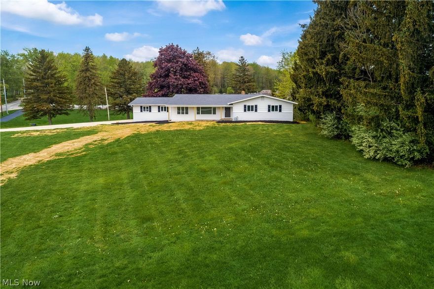 It doesn't get much better than this stunning ranch perched on over an acre lot in Brimfield Twp with newly installed access to public water and sewer! Completely renovated inside and out with high-end, quality finishes! The covered front porch leads into the living room with large windows that flood the space with natural light. Newly refinished hardwood floors throughout the entire first floor are a warm contrast to crisp white trim and molding. This kitchen is a total knockout...featuring two toned, soft-close cabinetry, stainless appliances, tiled backsplash, quartz counters and a massive center island! The adjacent great room has a cozy fireplace and access to the new deck overlooking the backyard. The guest bathroom is remodeled with modern finishes, tile flooring and a tiled tub surround! Three generously sized bedrooms include a spacious owner's suite with a remodeled en suite bath featuring a custom tiled shower and a white vanity topped with a quartz countertop. The finished,