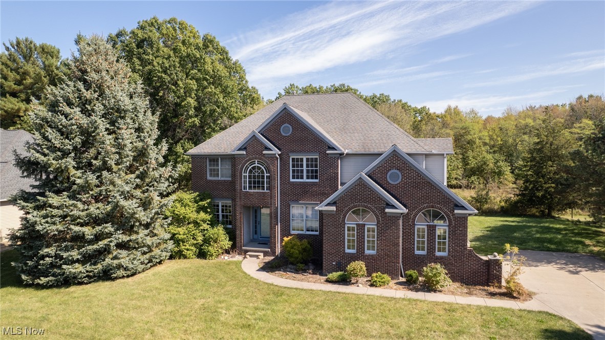 Nestled in Vermilion, a quaint coastal city on the shores of Lake Erie, prepare to embrace lake breezes, sunset strolls along the coast, and a relaxed Vermilion lifestyle just moments from the quaint downtown. The brick-front façade of this home welcomes you to a premium lot that backs to a serene, wooded sanctuary, offering privacy and a sense of timeless elegance. Inside, soaring ceilings elevate the two-story foyer and great room, flooding the space with natural light that makes daily living bright and effortless and entertaining a joy. The chef-inspired kitchen anchors the home with modern white cabinetry, abundant countertop space, and a generous eat-in area that overlooks the deck and lush yard, while easy access to the adjacent dining and living spaces keeps gatherings seamless. The main floor includes a fifth bedroom with a full bath—perfect for guests or a quiet in-law suite—plus a private office with French glass doors opposite to the dining room and a convenient first-floor laundry, all arranged to maximize flow and flexibility. The basement is fully finished with half a bath and the capacity to become a full bathroom, presenting a sizable canvas for a future media room, gym, or play space, with ample storage. Outdoors, a spacious deck with a motorized sun awning beckons warm evenings and a hot tub for snowy days, alfresco dining, and sunset-watching, while the surrounding yard and wooded backdrop deliver serene privacy. Additional highlights include energy-efficient windows, recessed lighting, premium millwork, and a thoughtfully designed layout that balances luxury finishes with everyday practicality, making this residence not just a home but a refined lifestyle in Vermilion’s most coveted community. This home blends small-town charm with easy access to marinas, cute shops, and unique lakeside dining in a city that has been voted as Ohio’s Best Beach Town on the East shores of Lake Erie.