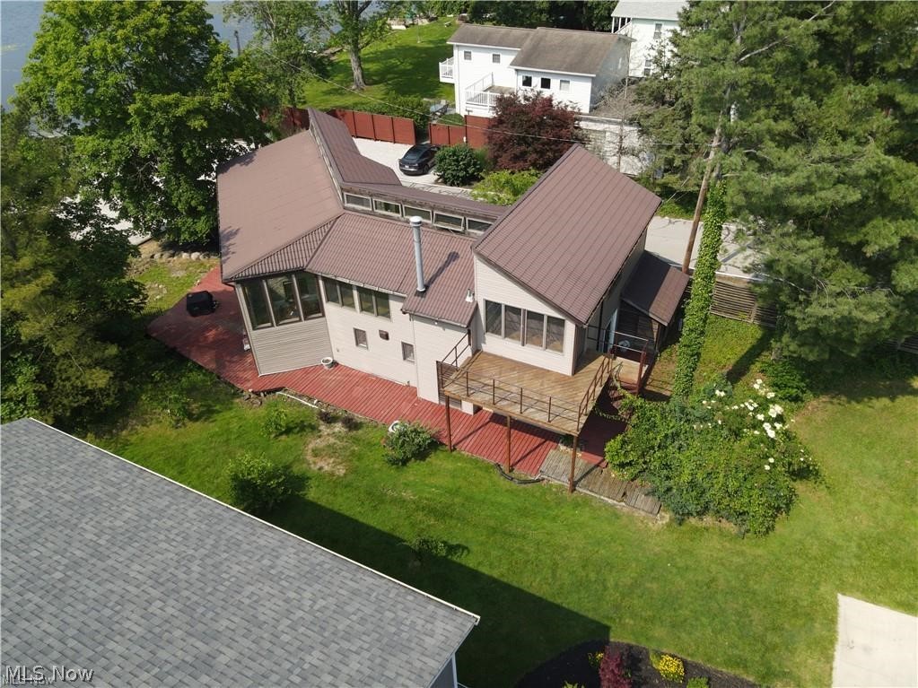 Lake living at its finest! This amazing home gives you gorgeous water views from both levels. Sit out on the back patio and relax with a cup of coffee or enjoy a book in the summer breeze. The floor to ceiling windows allows an abundance of natural light into the home, while giving breathtaking views of the water. The open concept throughout the entire home is ideal for entertaining and hosting. New flooring was installed in June of 2024, and gives a modern feel throughout. The gourmet kitchen has a large island with beverage cooler installed, granite countertops, stainless steel appliances and updated cabinets. The kitchen opens up directly to the dining room and the two-story living room. There is a bedroom on the first floor with large full bathroom and walk-in closet. There is an additional half bathroom and laundry room on the first floor. The unique spiral staircase leads you to the completely open upper level, which gives you a bird's eye view of the lake. There are two separate loft spaces and an additional oversized bedroom that is connected to another full bathroom. The attached 2-car garage gives ample space for your automobiles and additional storage. With lake privileges, you can drop your kayak directly off the public dock near your backyard, or put your toes in the sand of the public beach area. Recent updates to the home include two splits, flooring throughout the first floor, first floor bathrooms, gourmet kitchen and much more! Seller is requesting a minimum of a one year lease and pets are permitted. Seller would like to be contacted prior to showings please call Leslie at 330-592-1529 and then can arrange a showing with AGENT.