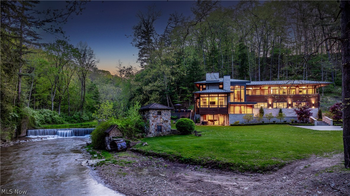 Situated on 19+ acres in the Yellow Creek Valley, this architectural triumph is unlike anything currently on offer. A contemporary study in glass, wood and stone, this home was meticulously designed to frame the incredible views of the surrounding hillside and waterfall, with historic turn of the century remnants from the previous estate including a mill wheel, stone horse bridge, dovecote, and bath house that punctuate the property. The river runs the entire length of the acreage, accompanied by shale cliffs, trails and natural pools that serve as your own private park. The entire home was designed for entertaining, with great care to capture a sense of spaciousness, openness, and natural light. French oak floors and stained cedar ceilings bring warmth to the open spaces. An expansive chef's kitchen, massive great room, multi level deck, and various fireplaces are the hallmarks of the first floor. Throughout the home, floor to ceiling windows frame the natural setting, incorporating the serene views into every aspect of the home. Upstairs, the owner's suite includes a fireplace and a balcony, plus an en-suite bath with an oversized steam shower and heated floors, and a dressing room with a coffee bar, island, and private terrace. In the guest wing, 3 bedroom suites share a bluestone balcony with views of the hillside and river. The walkout lower level includes a family room with a 10-ft fireplace, a wet bar, and a full bath.