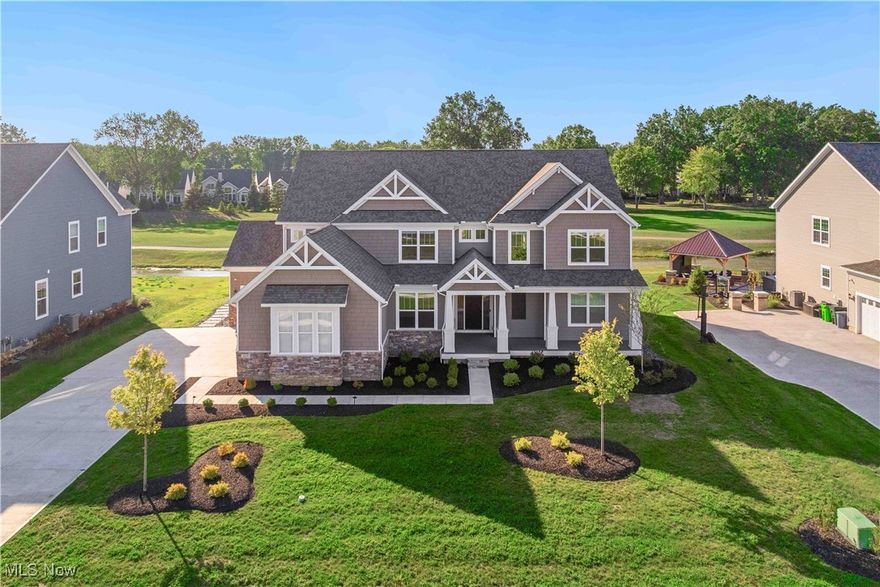 No need to build—welcome to the Skyview plan, thoughtfully designed to impress with its wide-open, light-filled layout and custom finishes throughout. Perfectly situated in the premier golf course community of Legacy Isle in Avon Lake, this home rests along the pristine 3rd hole, showcasing serene views of the pond, golf course, and wooded backdrop. The gourmet kitchen is a chef’s dream, featuring adjustable soft-close cabinetry with rollouts, hidden trash storage, double ovens, and quartz countertops. Entertaining flows seamlessly with luxury plank flooring, soaring 9’ ceilings, and thoughtfully designed gathering spaces. The main level also includes a spacious laundry and pantry area, a versatile office/living room, a planning center, and an oversized formal dining room perfect for hosting. Upstairs, the grand owner’s suite offers a retreat area, walk-in closet, and spa-inspired bath with custom details. Three additional bedrooms each include their own walk-in closet and attached bath, along with a versatile loft/game room. The fully finished basement provides exceptional additional living space with a full bath, dedicated craft room, and ample storage. Outdoor living shines with a covered porch, paver patios, built-in gas fire pit, and professional uplighting—all overlooking the pond and golf course for a truly serene setting. Additional highlights include a 4-car side-entry garage with a separate carriage bay, plus walking-distance access to the pool, clubhouse, golf course, and restaurant.