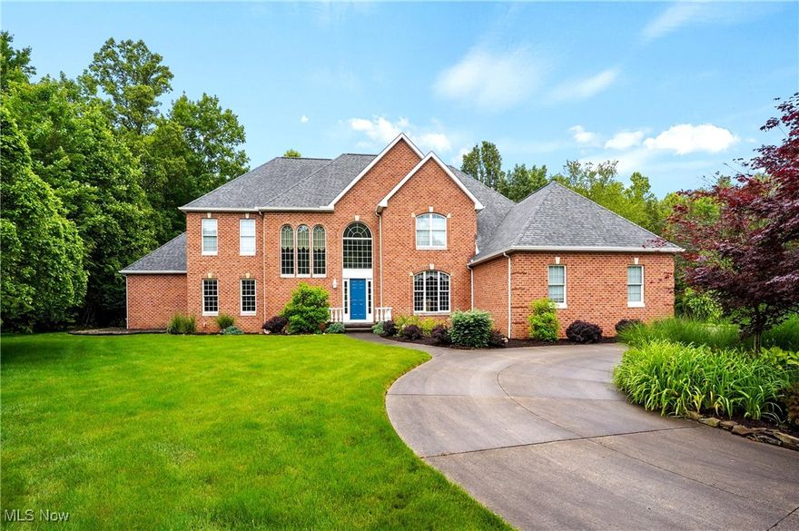 Exceptional all brick, custom built Georgian colonial nestled on 2.4 wooded acres at end of cul-de-sac presents gleaming hardwood floors and superb design throughout.  Welcoming front porch leads to a grand foyer with open staircase, Palladian windows, fluted columns and views of the rooms beyond.  Engaging two story great room highlights wall of glass offering an abundance of natural light and a gas fireplace.  Exquisite formal dining room features stacked crown molding and glazed wainscoting.  Two entries to the distinguished, handsome library with coffered ceiling and glass door to sandstone patio. Guest bath conveniently located.  Luxurious first floor owner's suite boasts tray ceiling, bayed windows, his/her WIC, access to the outdoors, and glamour bath with H/H vanity and water closet.  Gourmet kitchen offers glazed cabinetry, granite counters, tile backsplash, center island/breakfast bar, all appliances, separate eating area with pitched ceiling, and access to patio. Spacious laundry room/mudroom features back staircase to second floor, garage access, and leads to separate suite.  This first floor in-law/teen suite is complete with bedroom, bathroom, living room multiple walls of windows, full kitchen w/fireplace, and private composite deck. The second floor hosts three generous sized bedrooms, one ensuite and the other(s) w/jack-n-jill bath, each w/separate vanity, along with the catwalk, that overlooks the foyer and great room.  Unfinished lower level (plumbed for bath) ready to be finished to buyers discretion. 3 c gar w/ stairs to LL.   Notable amenities include security system (connected to Bath Twp Fire), 2 HVAC, circular drive, stamped concrete patio.   POS completed.
