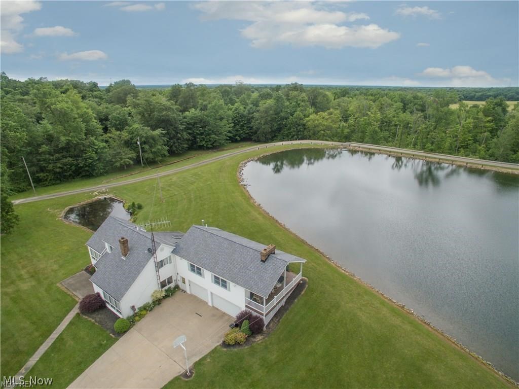 Absolutely Phenomenal 4 Bedroom Home with FREE GAS on almost 60 Acres of Land with Tons of Outbuildings & 10 acre, spring fed-stocked ski lake with slalom course, Concrete Boat Ramp, and 2 Modular homes currently rented for $1225 Each Month. Home Features Include: First Floor: Huge Custom Kitchen with Natural Hickory Cabinets, Center Island, & Tons of Cabinet Space, First Floor Living Room, Formal Dining Room, First Floor Laundry Room, & First Floor Master Bedroom/Master Bath Area with Awesome Private Loft. Second Floor Offers 2 Large Bedrooms & 2nd Full Bath. Above the Garage Features a Separate Suite offering a 4th Bedroom/2nd Master Suite, Separate Bath, Walk In Closet, & Awesome Sitting Room/Family Room with Cathedral Ceiling, Stunning Fireplace, & Trapezoid Windows with Stunning Views of the Lake. Home offers a 2&1/2 Car Heated Garage with water, Heated Work Shop with 220 Electric, Large Pavilion, Multiple Out Buildings, Rifle & Archery Range, and tons of Paths thru the woods and