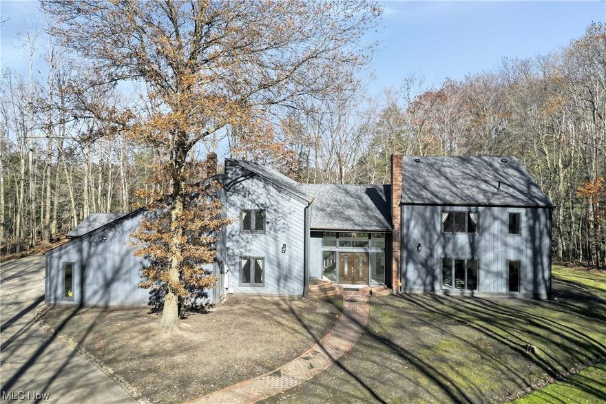 Prepare to be moved! This custom-built contemporary home, situated on 3.64 wooded acres with ravine views, is a tranquil retreat, special no matter the season! With over 3100 square feet of living space, and almost every tile, wall, ceiling, vanity, and light fixture replaced as well as fresh paint, you can enjoy the luxury of a modernized home. Take a tour of this dreamy abode and be welcomed by a grand foyer that flows into an open-concept great/dining room featuring a stone fireplace and wet bar. Discover the huge kitchen, complete with a center island, as well as a first-floor office that can double as a fourth bedroom.  Laundry with ample storage and 1.5 baths complete the main floor. On the second floor, the primary suite offers vaulted ceilings, a loft area overlooking the indoor pool, and a custom closet leading to a private luxury bath. There are also an additional two oversized bedrooms and another full bath. Take the fun indoors with a nearly 1,000-square-foot pool area. As if that was not enough to be excited about, check out the huge deck with a built-in covered hot tub and dining area perfect for entertaining. The three-car garages ensure that you have plenty of storage for all your needs, while the bonus of a generator and smart thermostat provides additional comfort. Enjoy the country setting and yet you are close to parks, schools, shopping, dining, and 271. With all these features, this unique property is sure to be a hit! Schedule a showing today and make this dream home your reality!