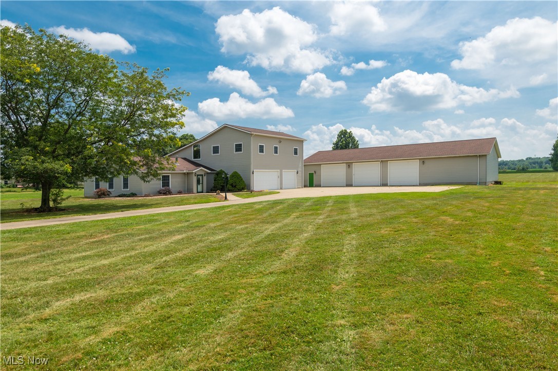 Set on over 9 acres of scenic countryside, this 4,900 sq. ft. Colonial home offers not only spacious, elegant living but also exceptional outbuildings, including a heated 40x80 structure with 12x11 garage doors, ceiling fans, and ample room for equipment, vehicles, or a workshop, plus a generous 39x24 three-car attached garage. Inside, the home features five bedrooms and 2.5 baths, blending classic design with modern amenities. The inviting living room with a gas fireplace leads to an expansive kitchen with a breakfast bar, quality appliances, and access to a deck overlooking the tranquil landscape. A first-floor bedroom and half bath offer convenience for guests or multigenerational living, while a dedicated office provides quiet workspace. Upstairs, a large great room and four additional bedrooms include a luxurious primary suite with a two-level layout, two-sided fireplace, full bath, and private hot tub room. Commercial-grade mechanicals, including an oversized hot water tank, ensure lasting efficiency in this rare blend of timeless charm, practical functionality, and serene rural setting.