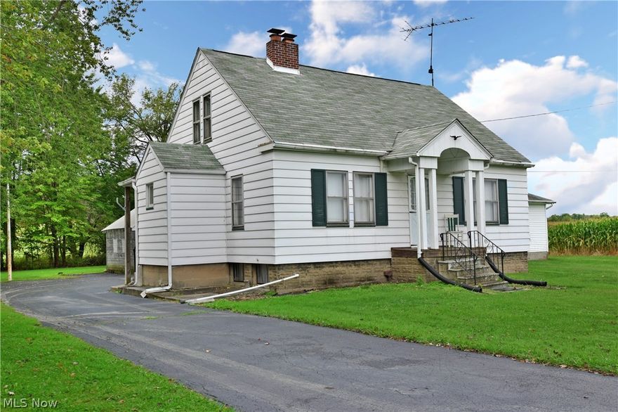 Enjoy the peaceful countryside views in this cozy, four-bedroom farmhouse! This property offers both a scenic lot and tons of garage space with its multiple outbuildings. The clean exterior highlights a covered front patio that leads into a sun-filled, carpeted living room; with a lovely central fireplace and white brick mantle. Thick baseboards run along the walls as you find built-in cabinets in the main hallway. Bifold doors hide the second-floor stairwell that leads to a pair of loft style bedrooms. The main floor features two additional bedrooms that sit on each side of a beautiful full bath. A large kitchen boasts eat-in dining space along with wood panel walls and matching cabinetry. A full basement below contains additional storage space along with a utility area. This house will need some updates but has been a well loved family home for years.